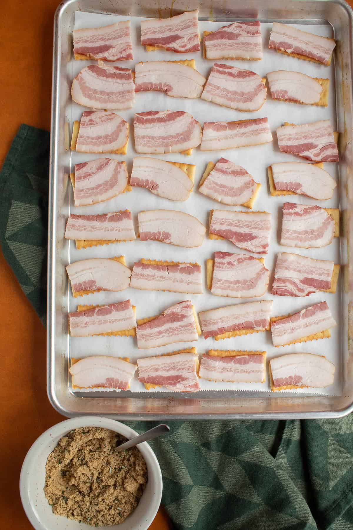 Each cracker is topped with a piece of sliced bacon.