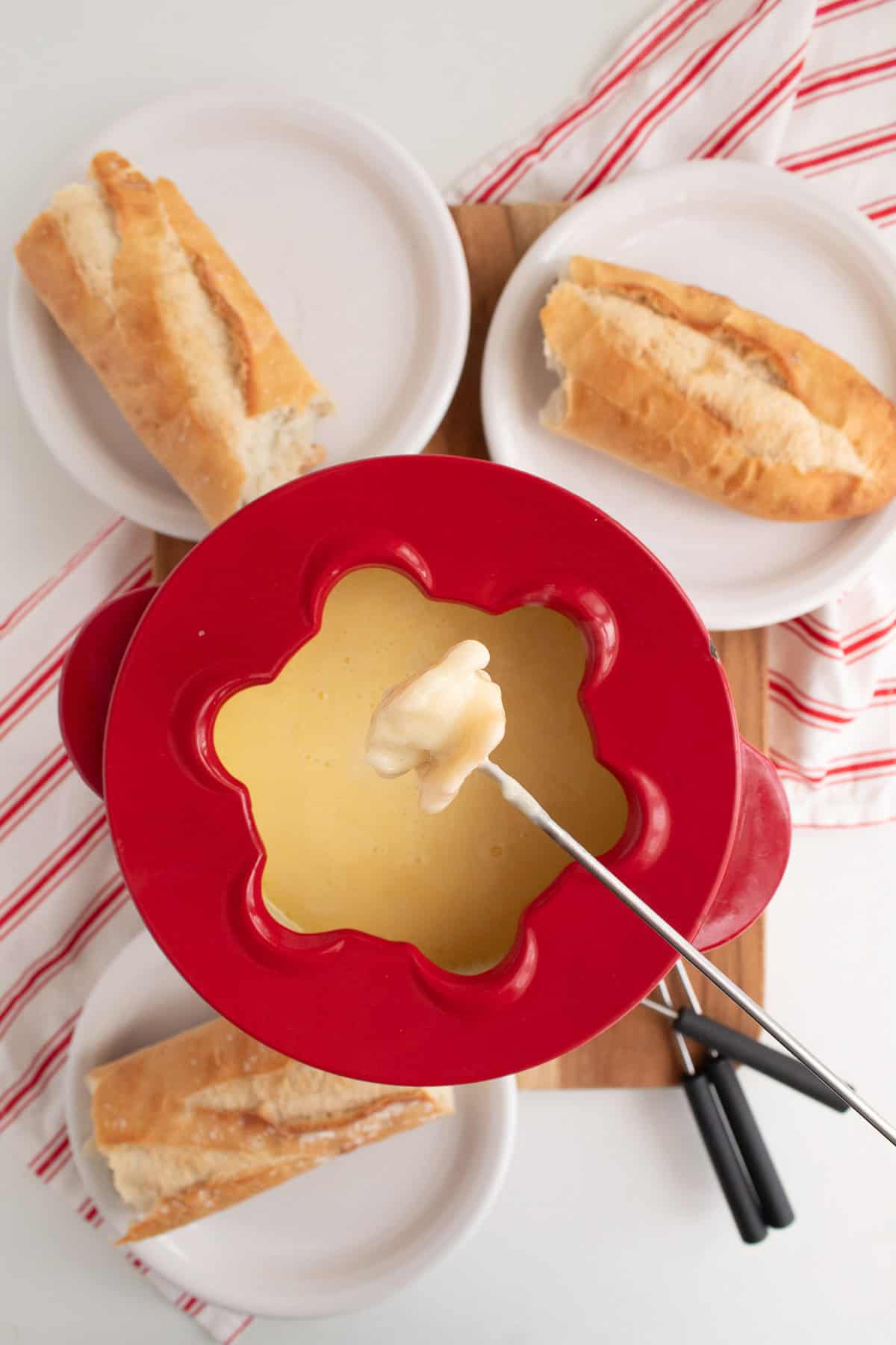 A piece of bread is dipped in the cheese fondue.