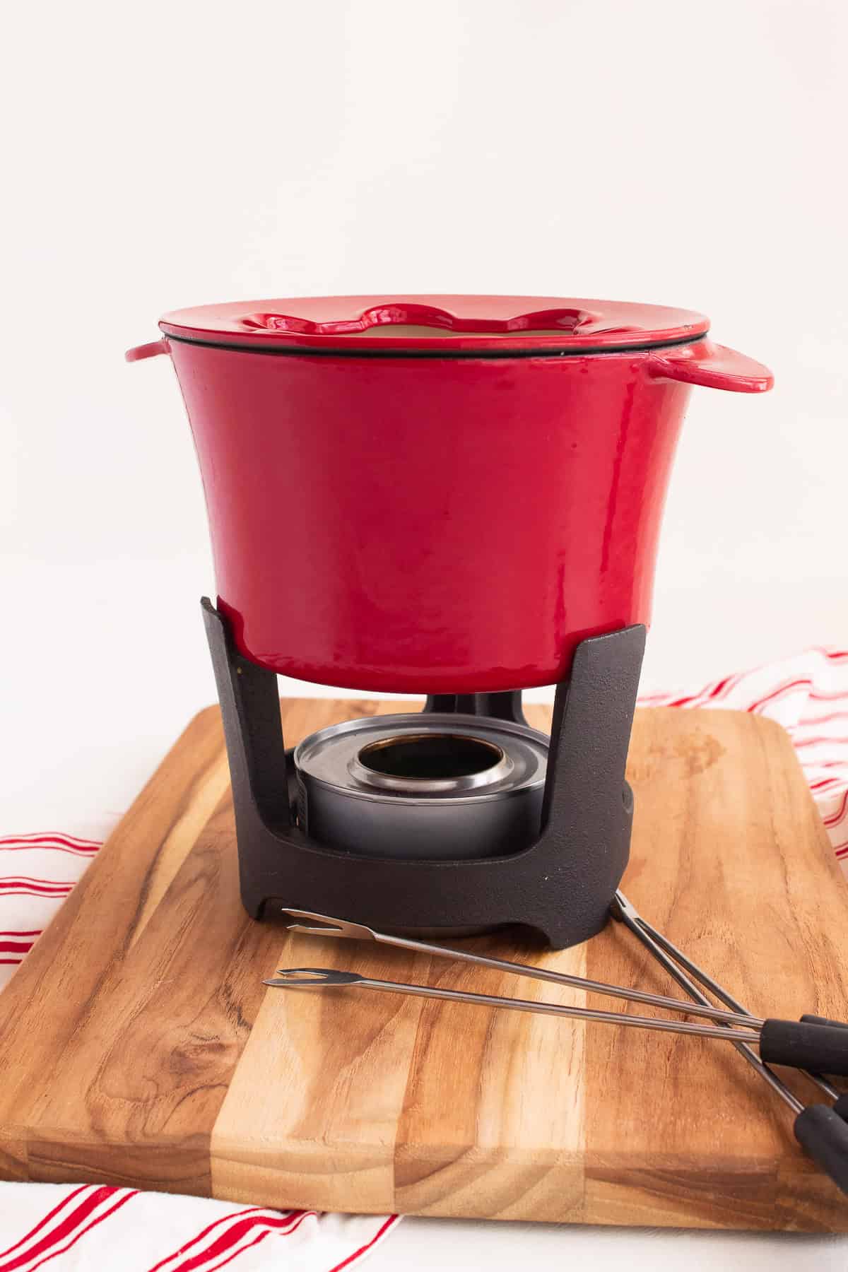 A fondue pot is placed on a rack over a gel heat source.