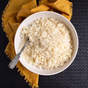 The baked rice is transferred to a white bowl for serving.