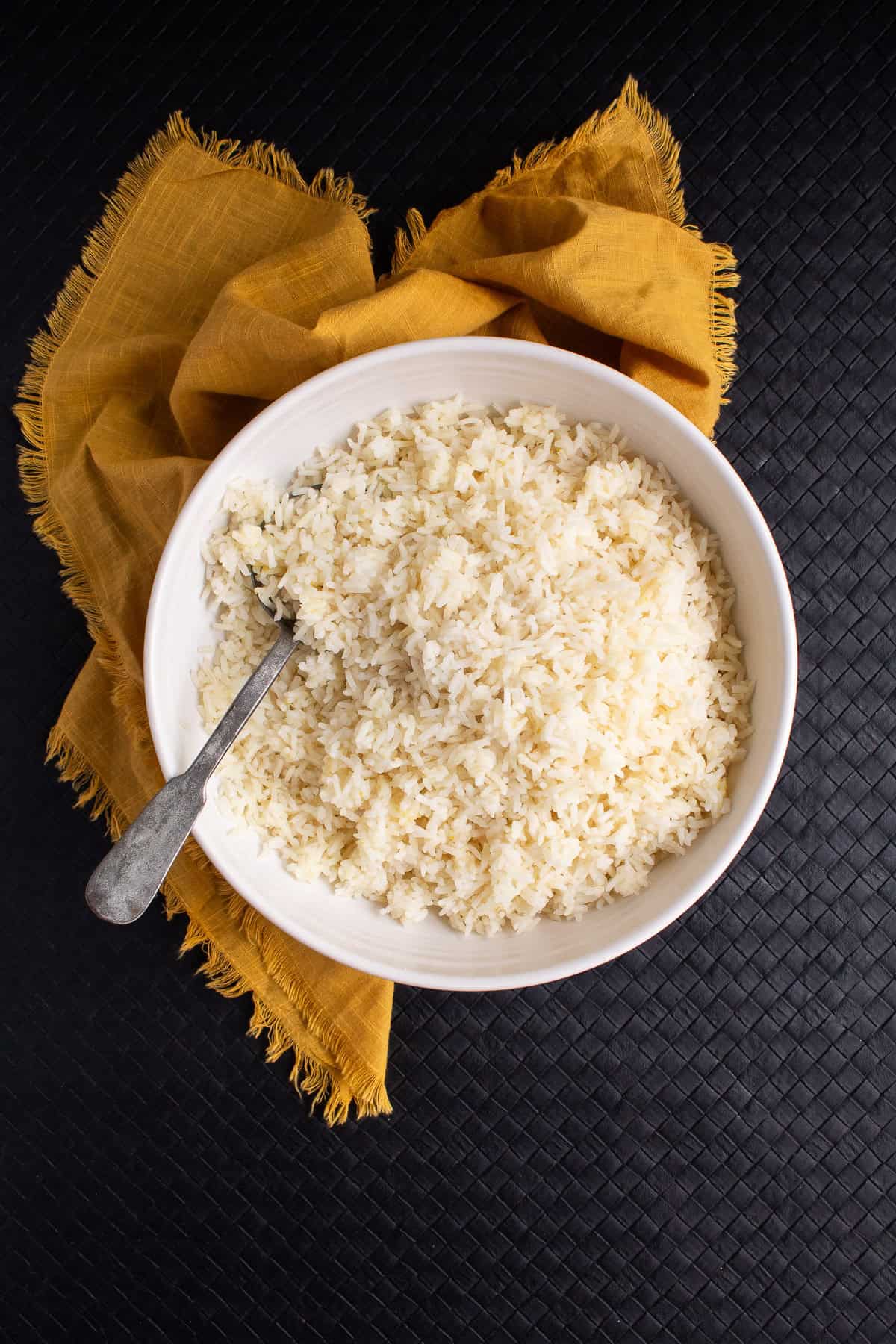 The baked rice is transferred to a white bowl for serving.