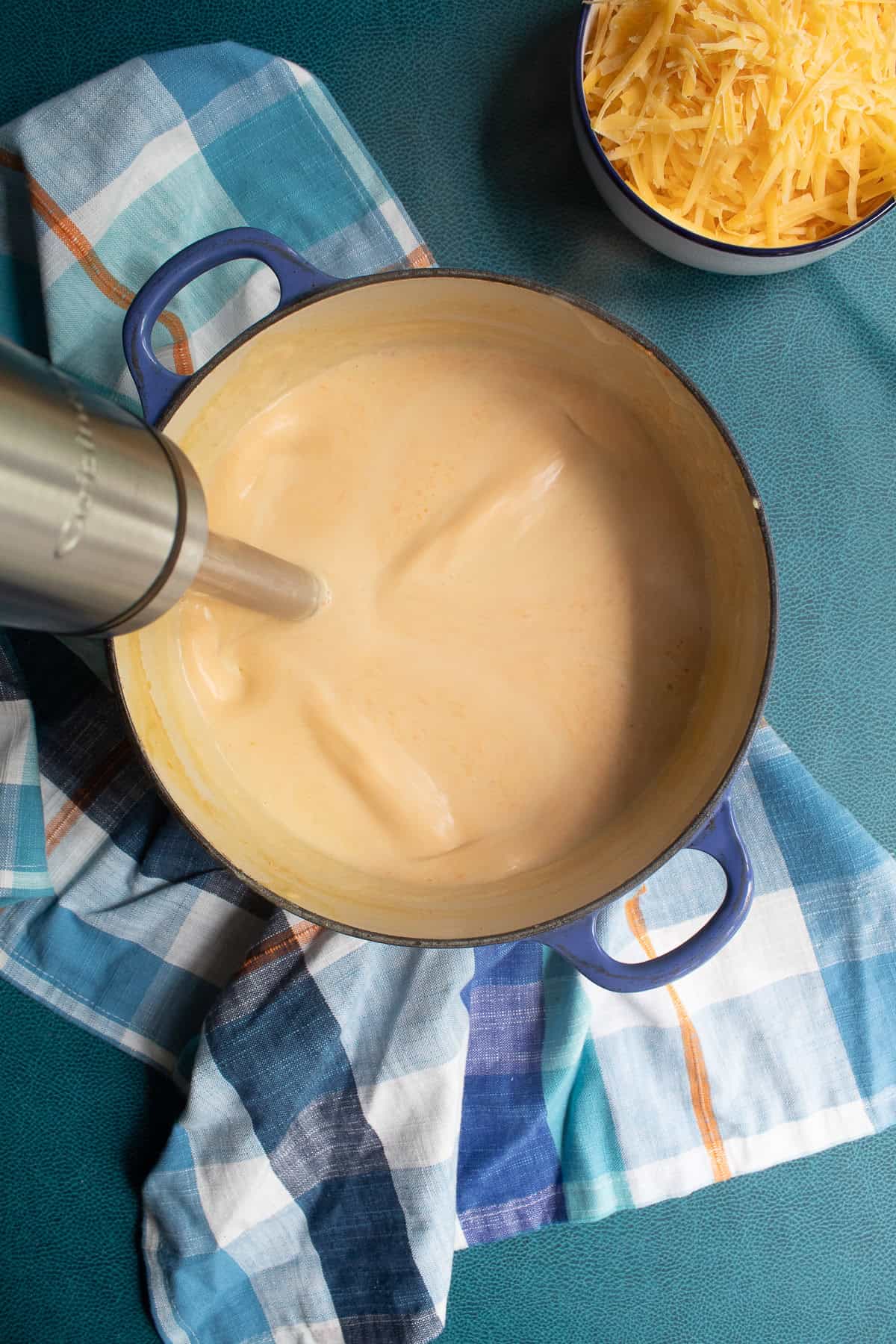 An immersion blender processes the simmered soup.