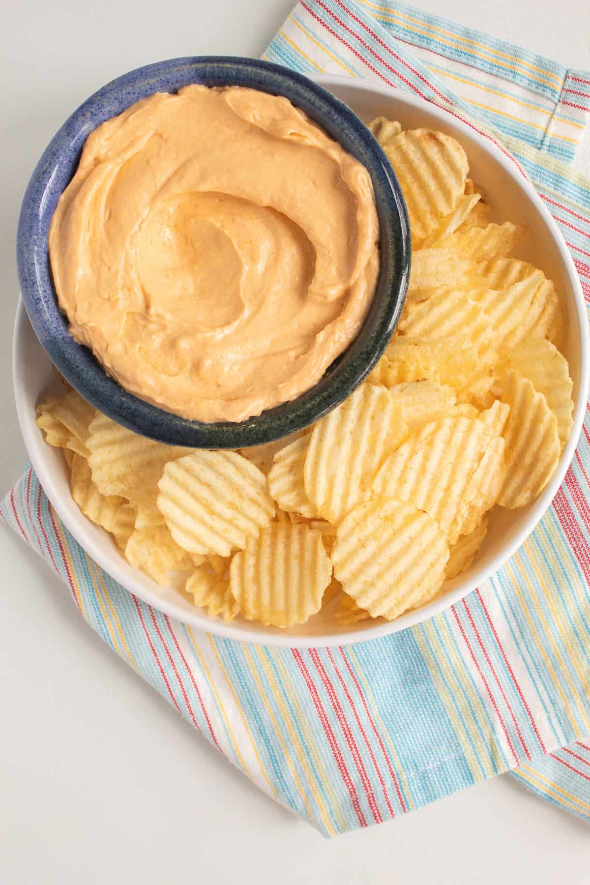 The soft whipped cheese spread is served with potato chips.