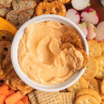 The thick cheese spread is served with pretzels, vegetables, and other crackers.