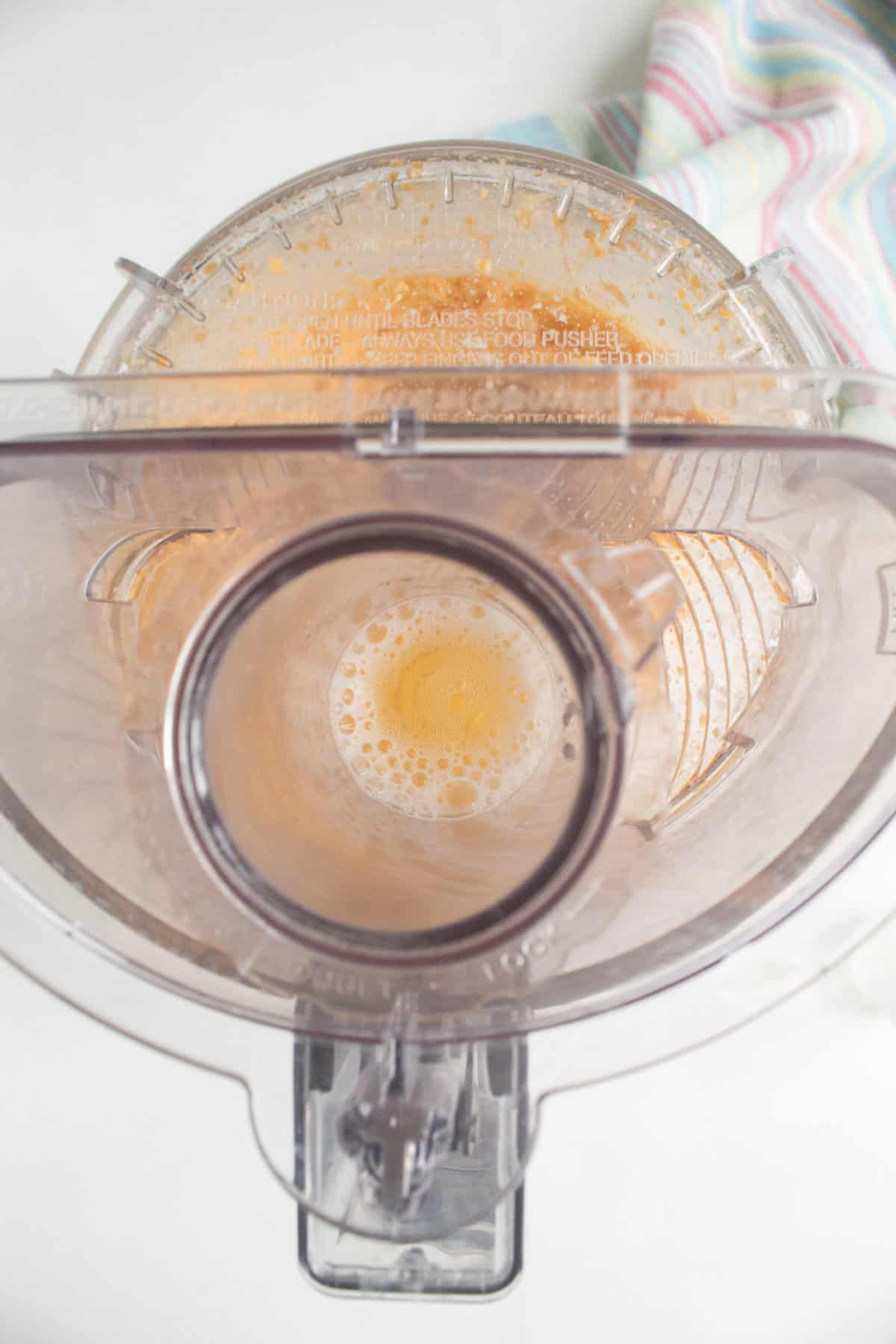 Beer is slowly streamed into the cheese mixture while the processor is running.