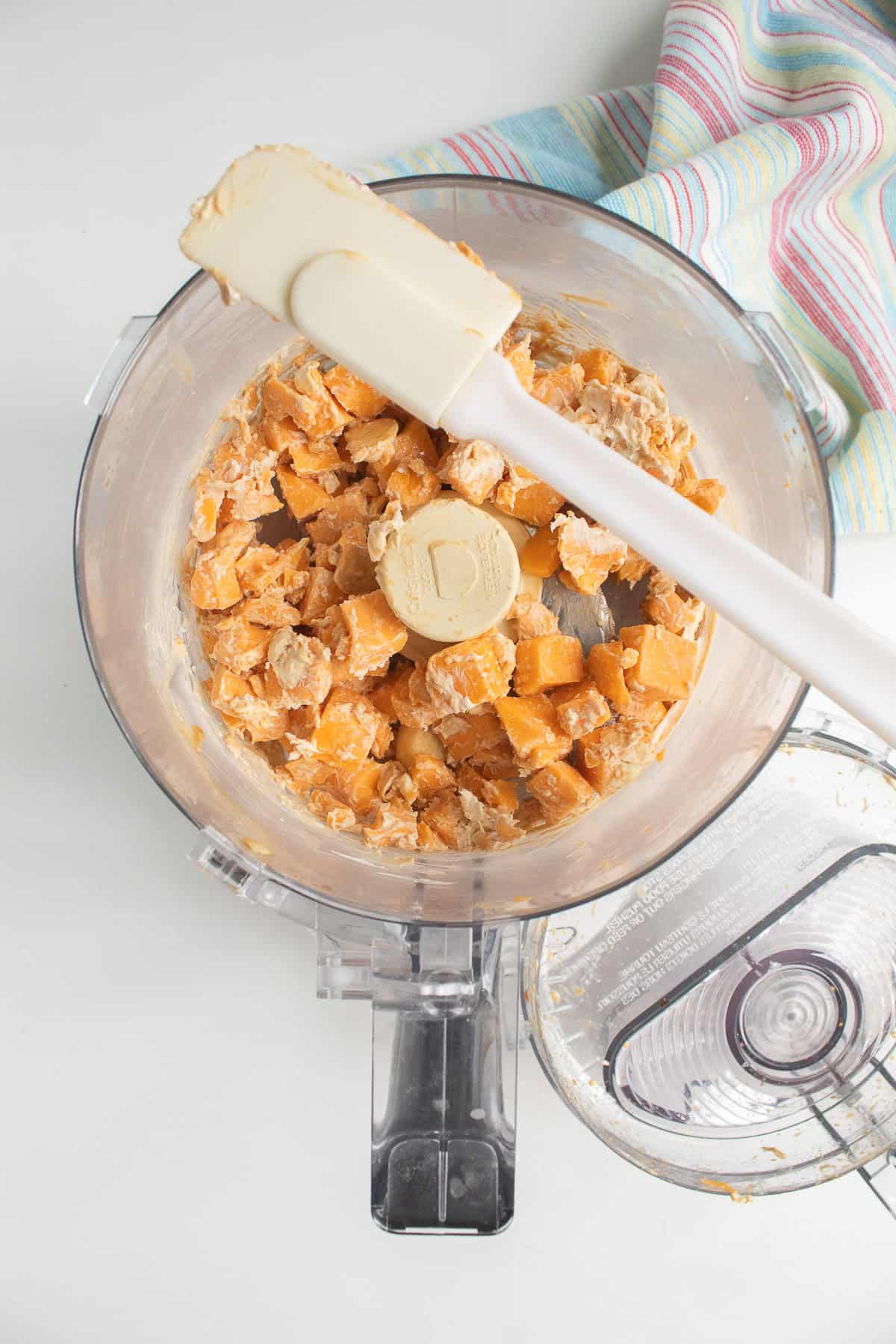 The sharp cheddar, cream cheese, garlic, and Worcestershire are pulsed to start processing and the sides of the bowl are scraped down.