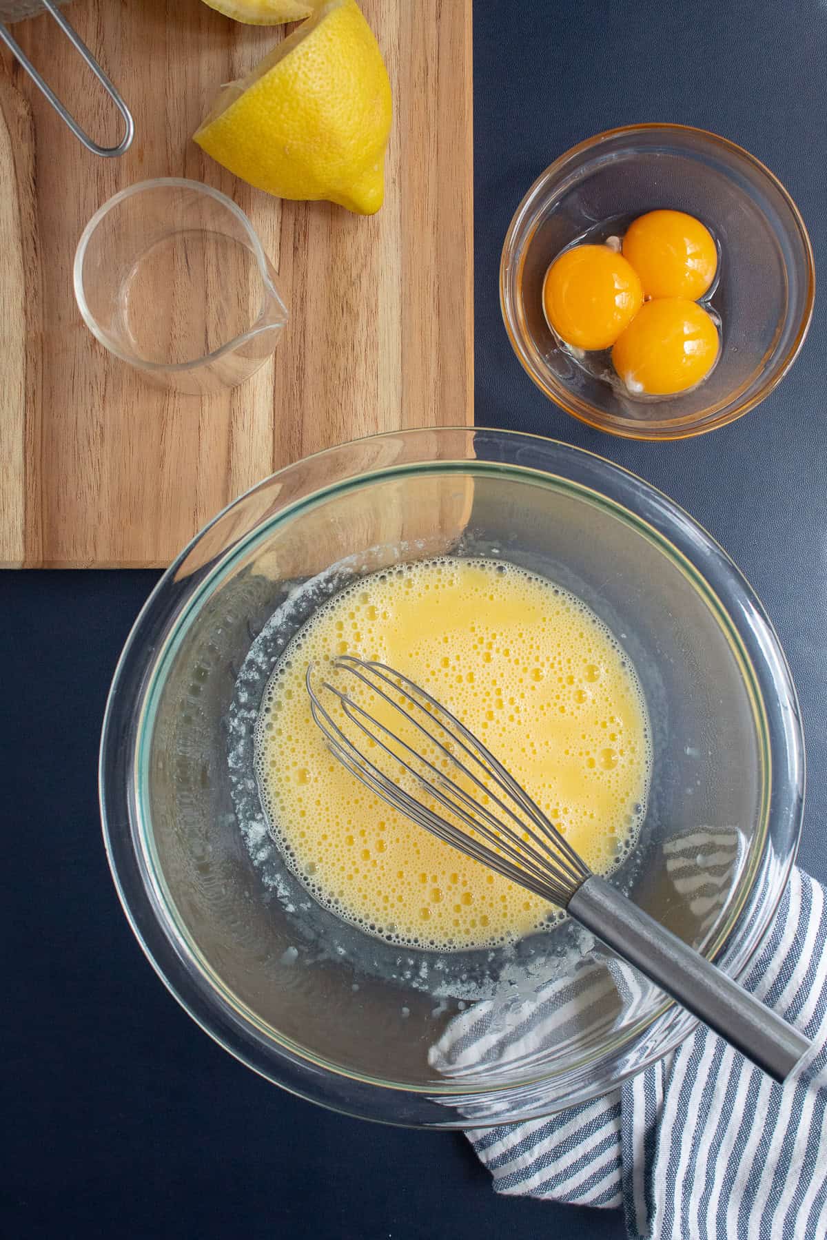 One egg yolk is whisked into the lemon juice and melted butter mixture.