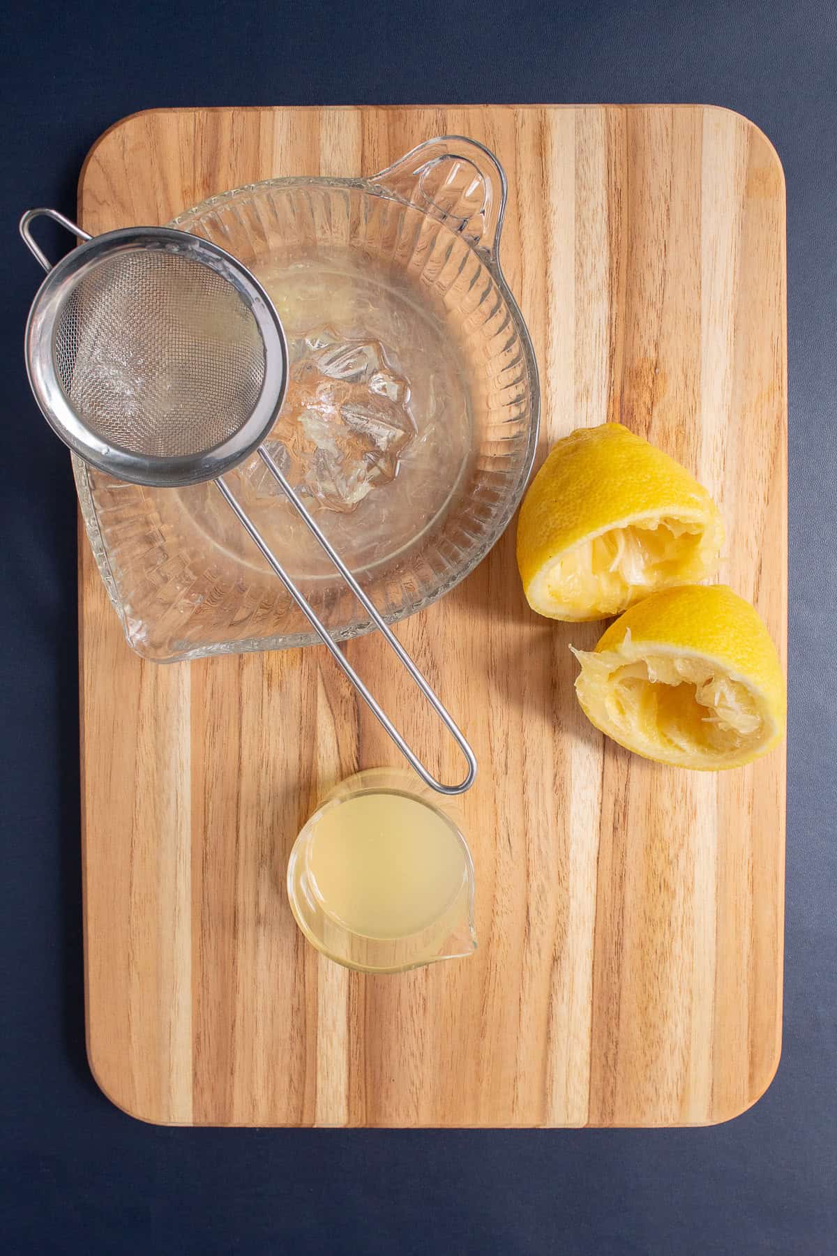A fresh lemon is juiced and the juice is strained to remove any pulp.