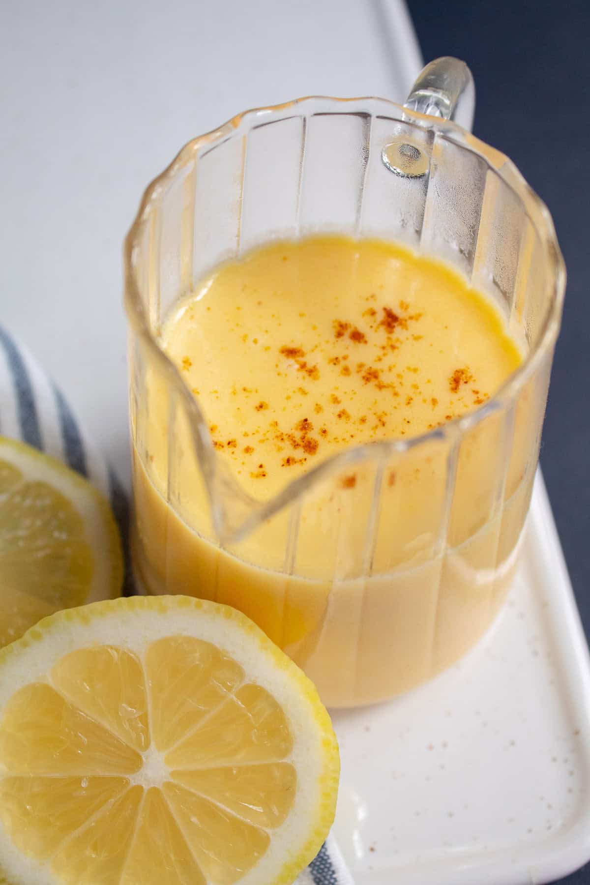 The finished sauce is transferred to a serving pitcher and garnished with extra ground cayenne pepper.