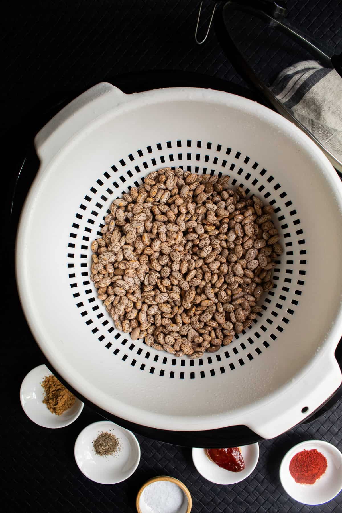 Pinto beans are rinsed and drained in a colander.