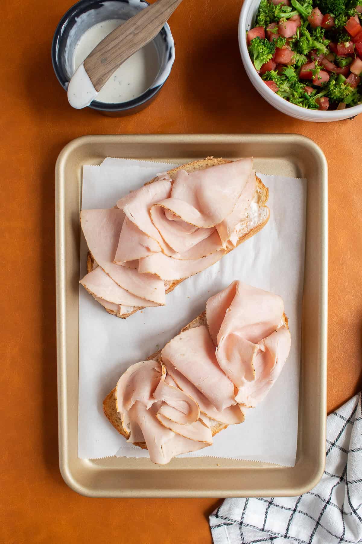 Turkey deli slices are heaped over the toasted sourdough.