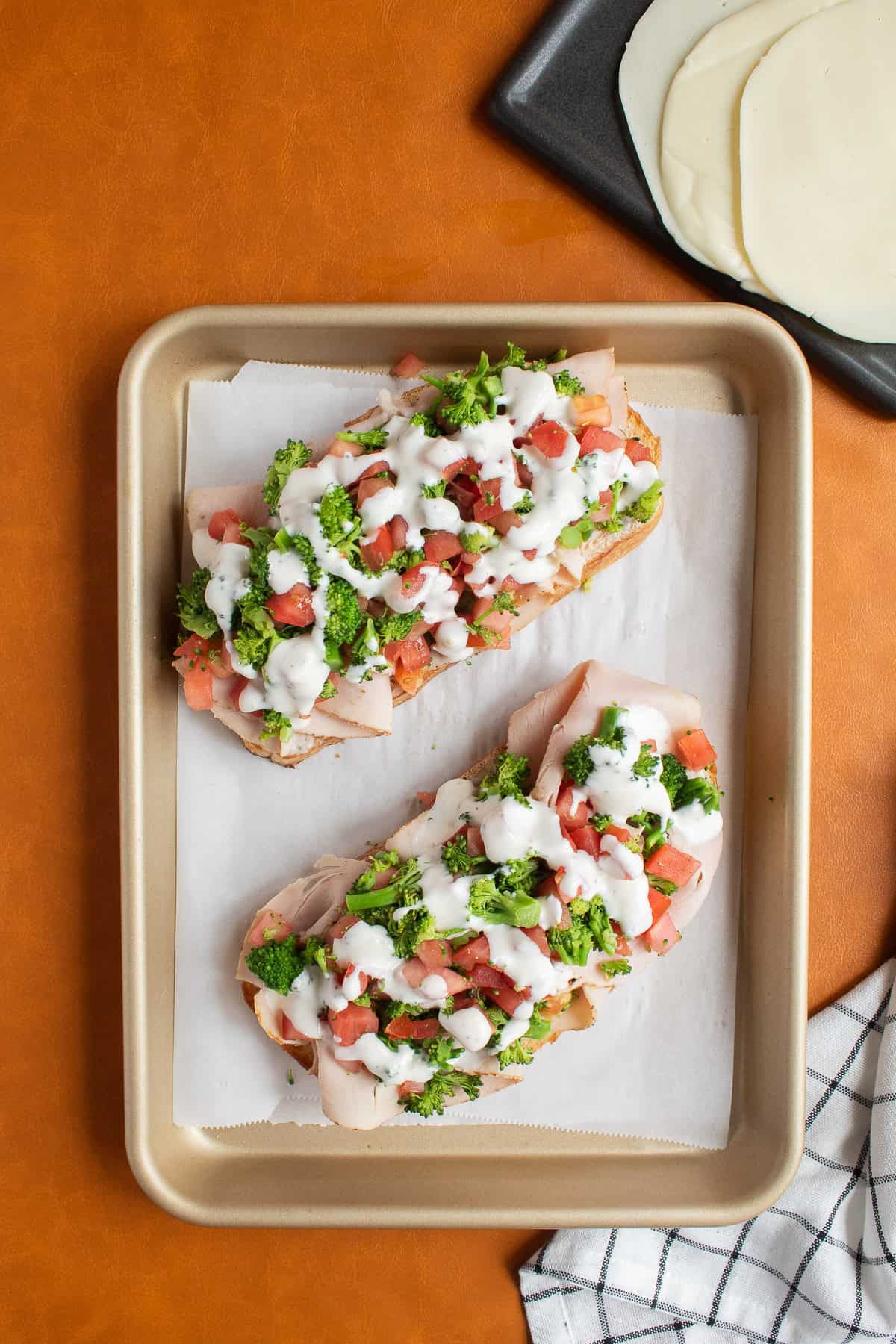 Ranch sauce is drizzled over the broccoli and tomato mixture.