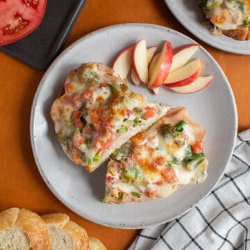 The broiled open faced turkey melt is served with apple slices.