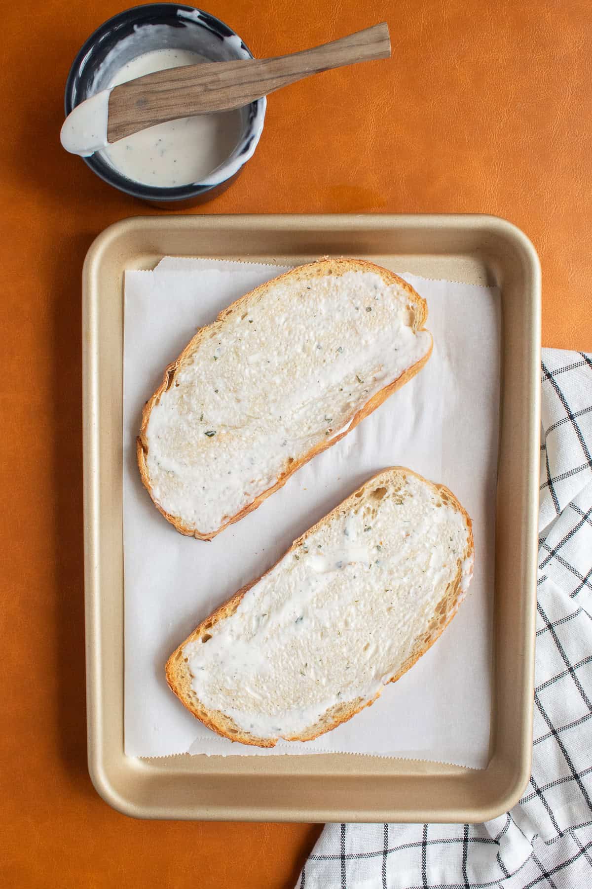 Toasted sourdough is slathered with ranch sauce.