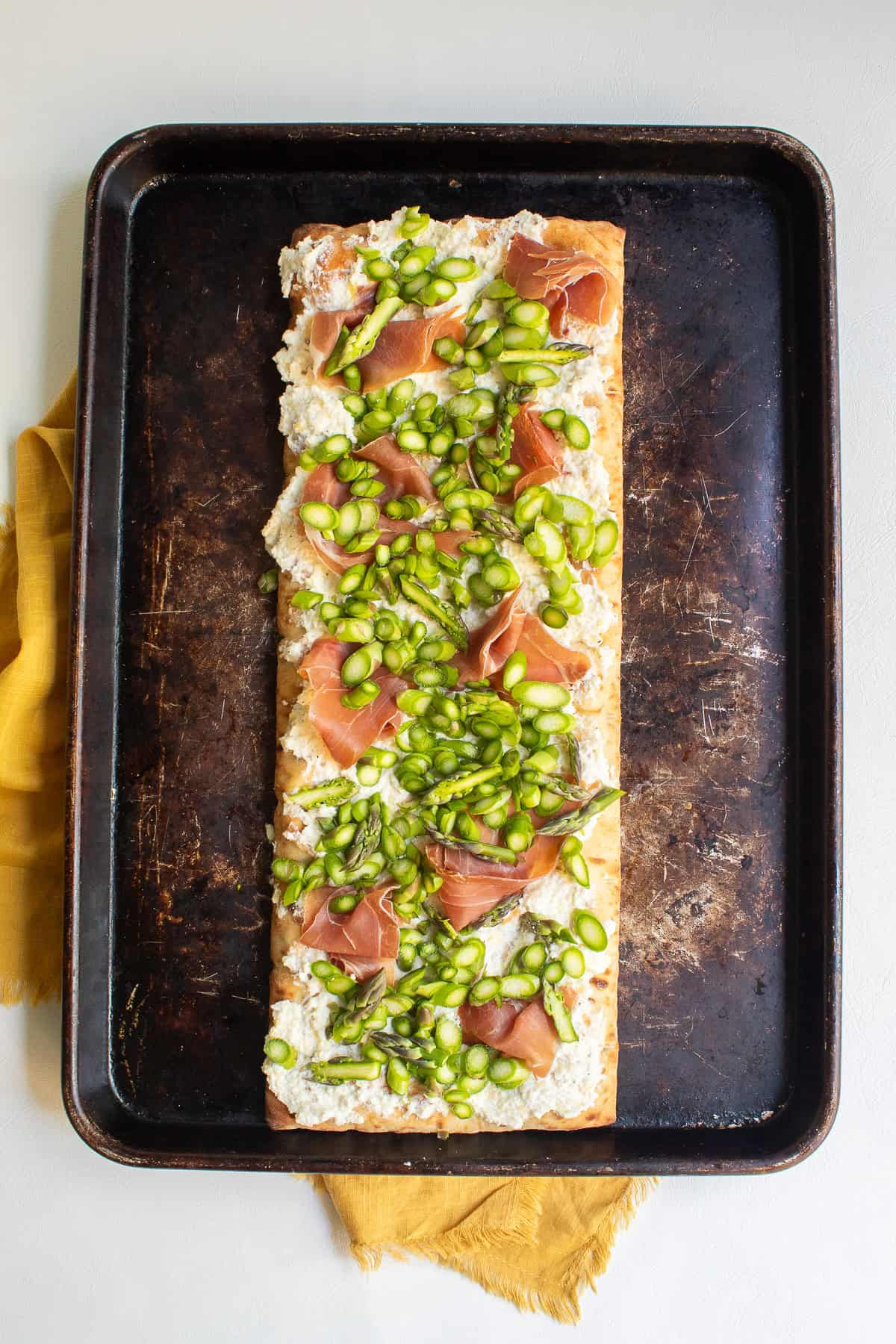 Asparagus is generously sprinkled over the prosciutto.