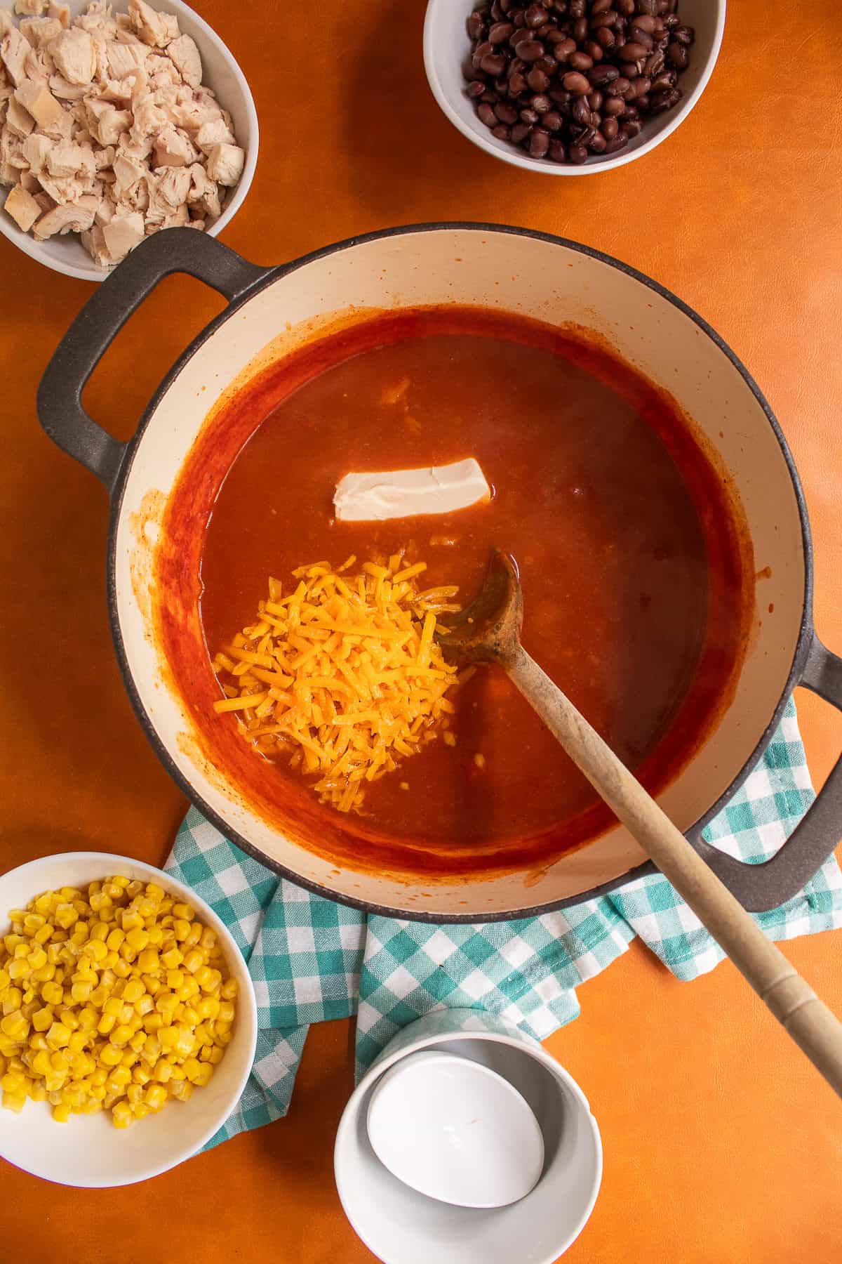 Cream cheese and shredded cheddar are added to the simmered soup.