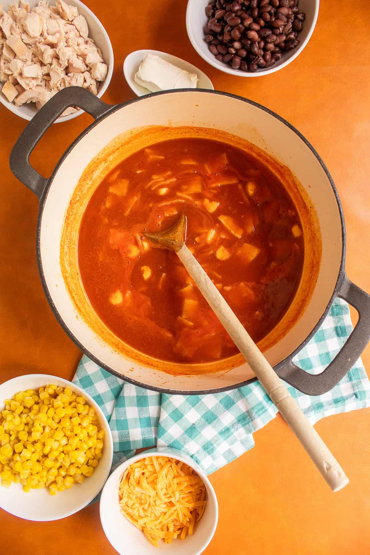 The tortillas soften in the bright red broth.