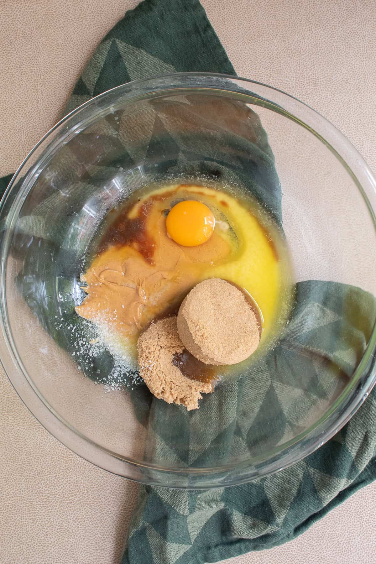 Melted butter, egg, vanilla, peanut butter ,and brown sugar are added to a large mixing bowl.