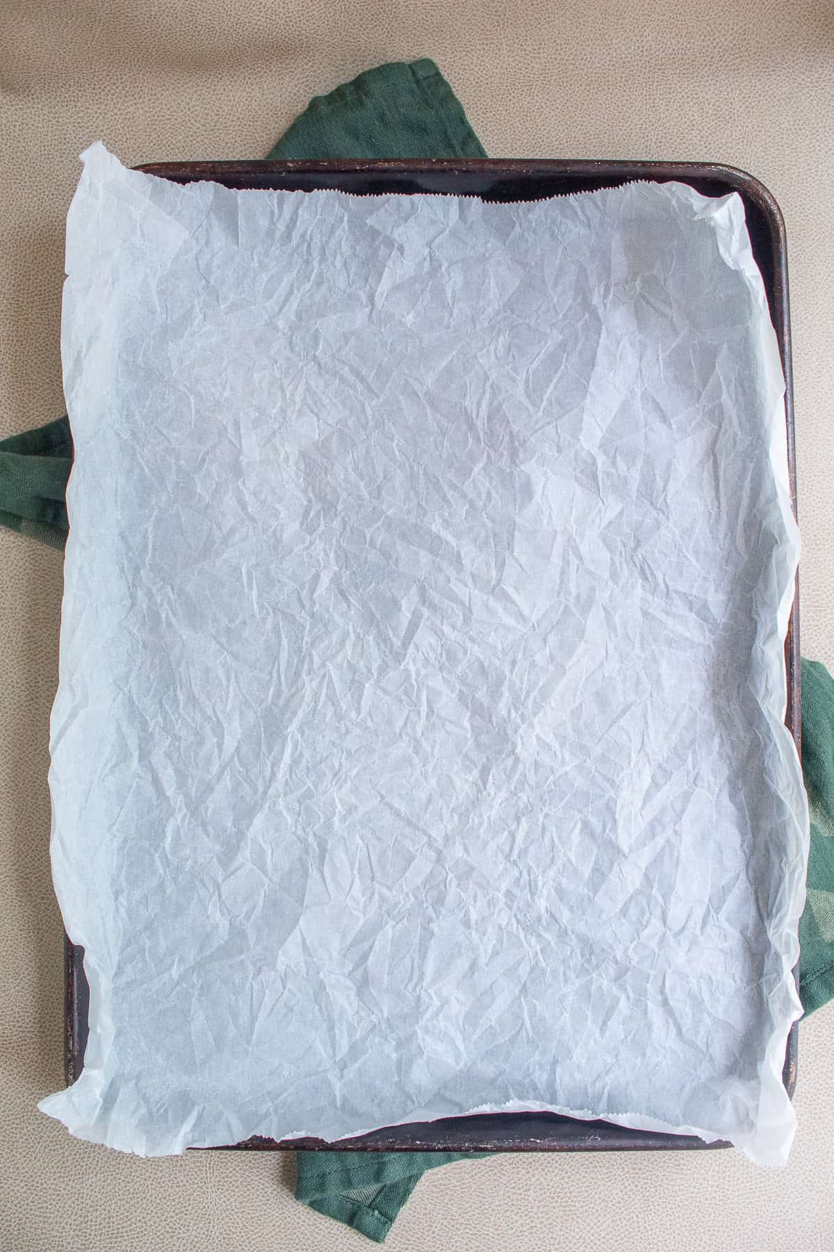A sheet pan is lined with parchment paper.