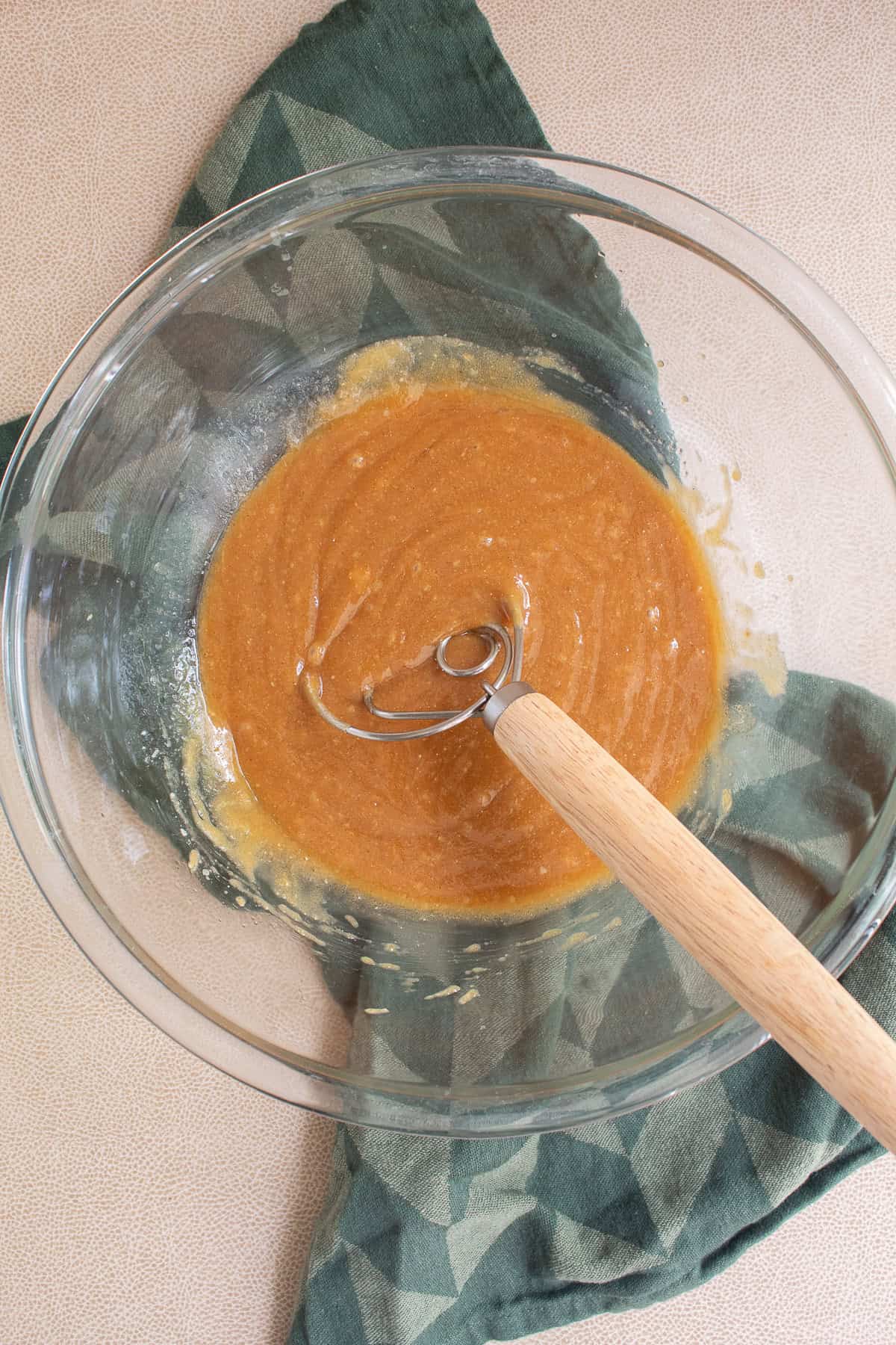 The wet ingredients are blended into a caramel-colored mixture.