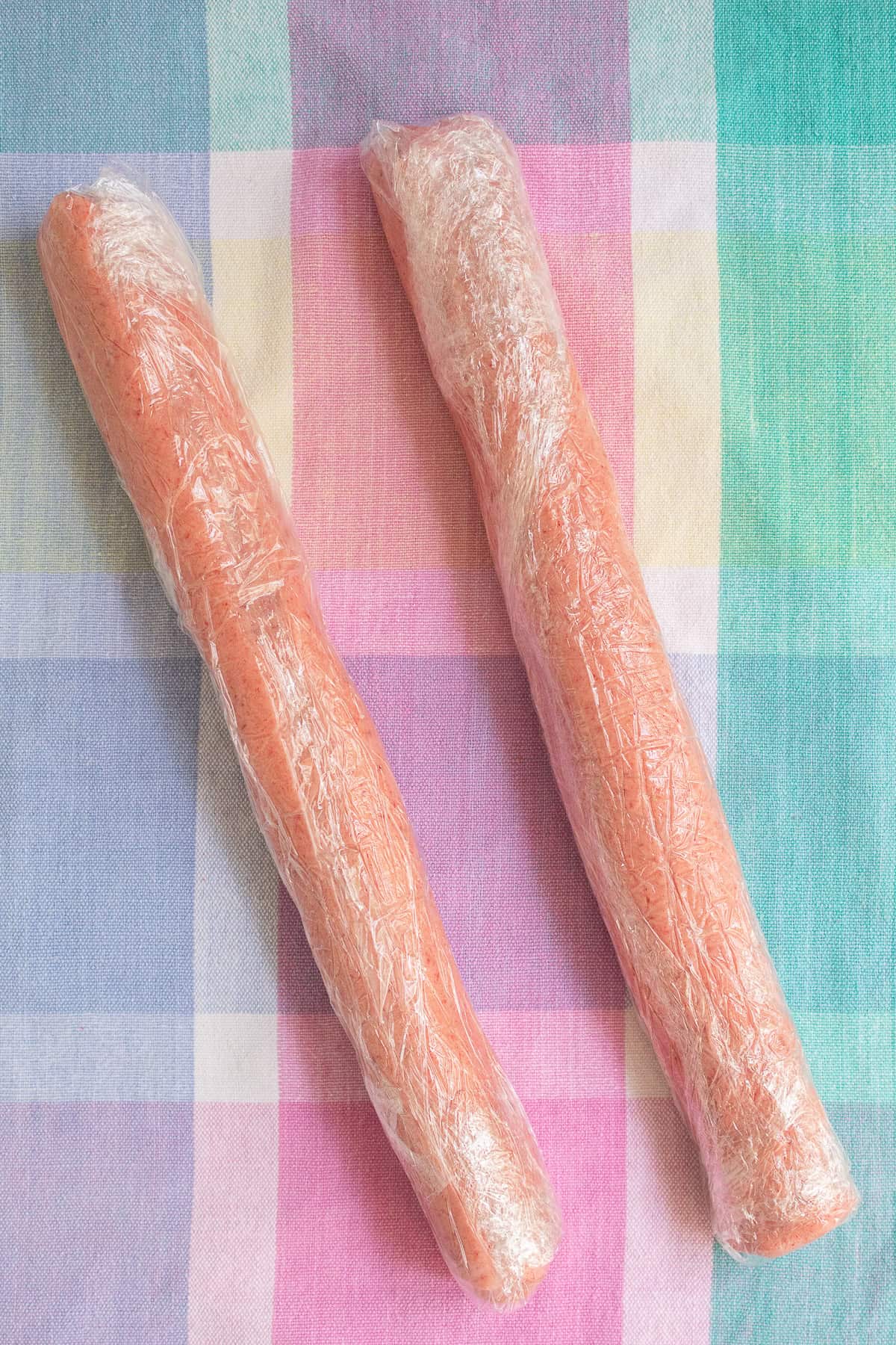 The dough is shaped into 12-inch logs and wrapped in plastic before chilling.