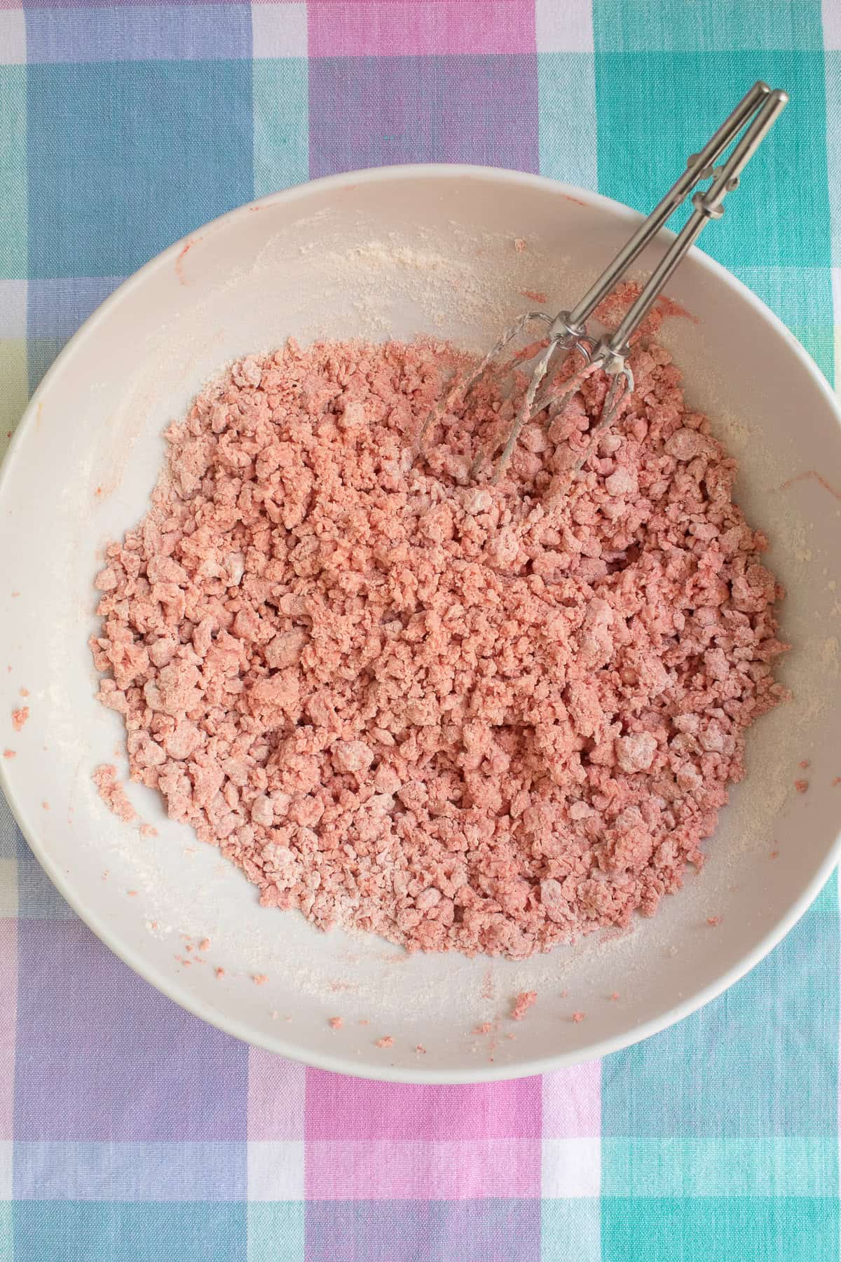 The flour is added to the butter mixture and the dough is very crumbly at first.
