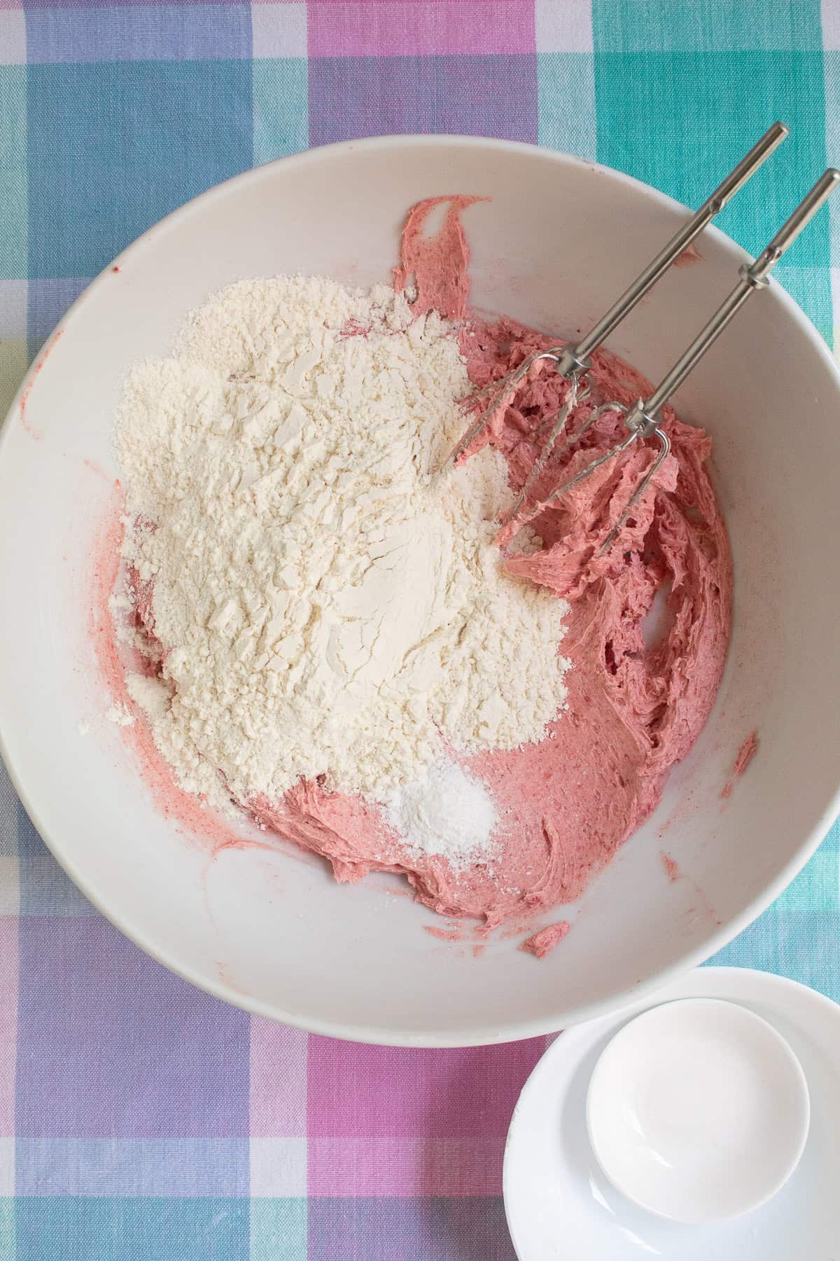 Flour and baking powder are added to the butter and sugar mixture.