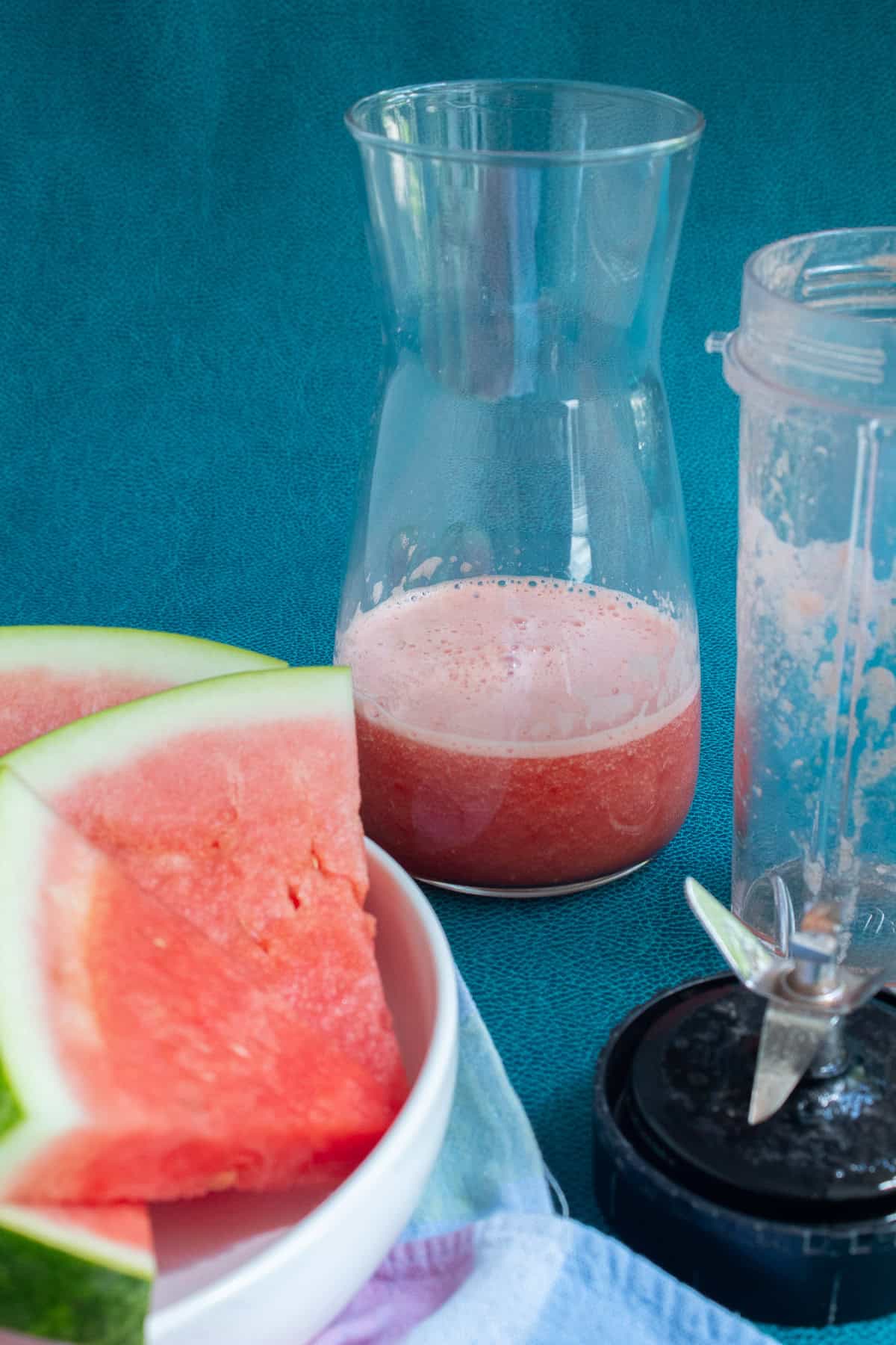 The lemonade concentrate is poured into a glass carafe.