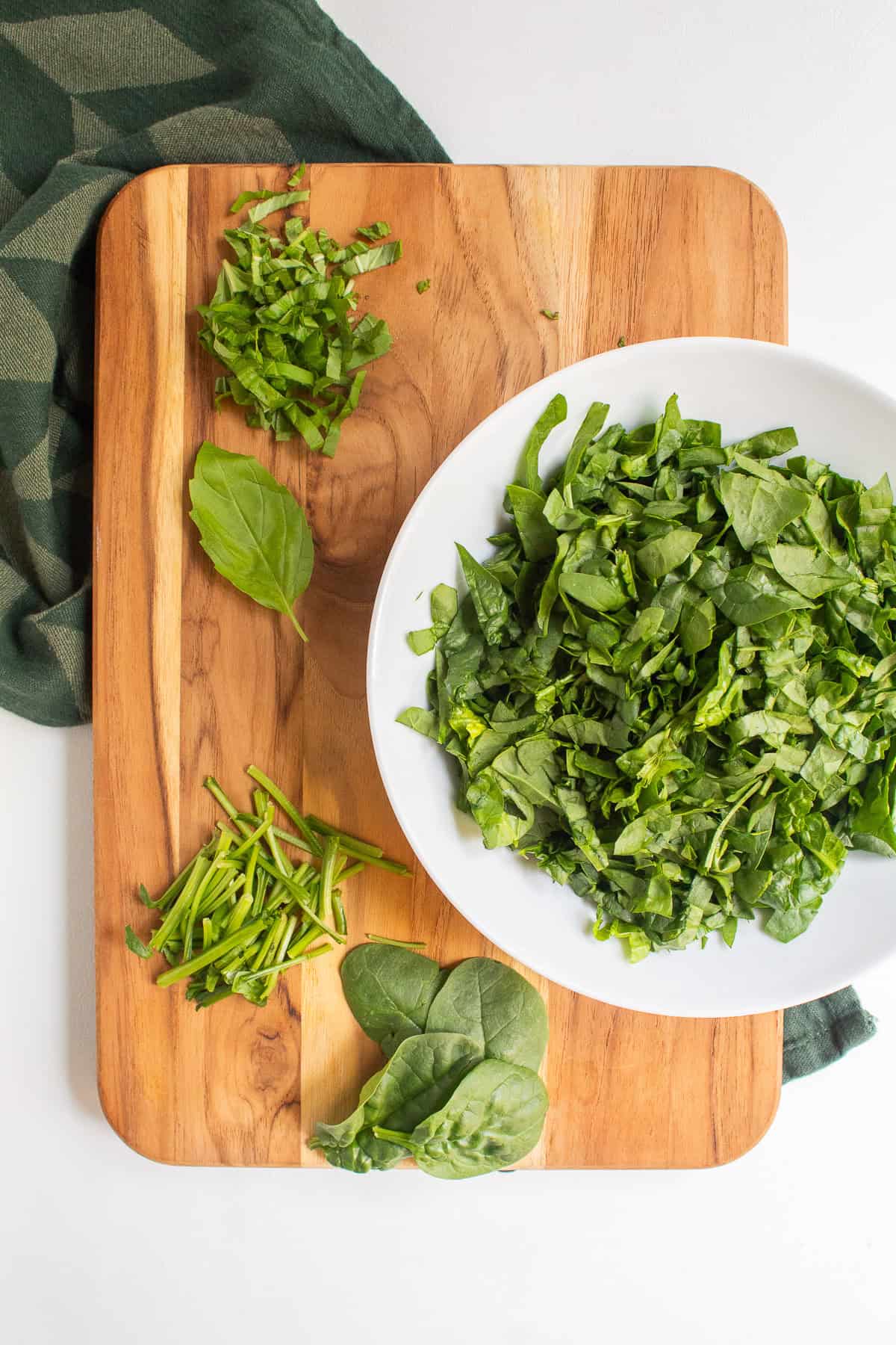 Spinach is shredded after the stems have been removed, while basil leaves are cut into ribbons.
