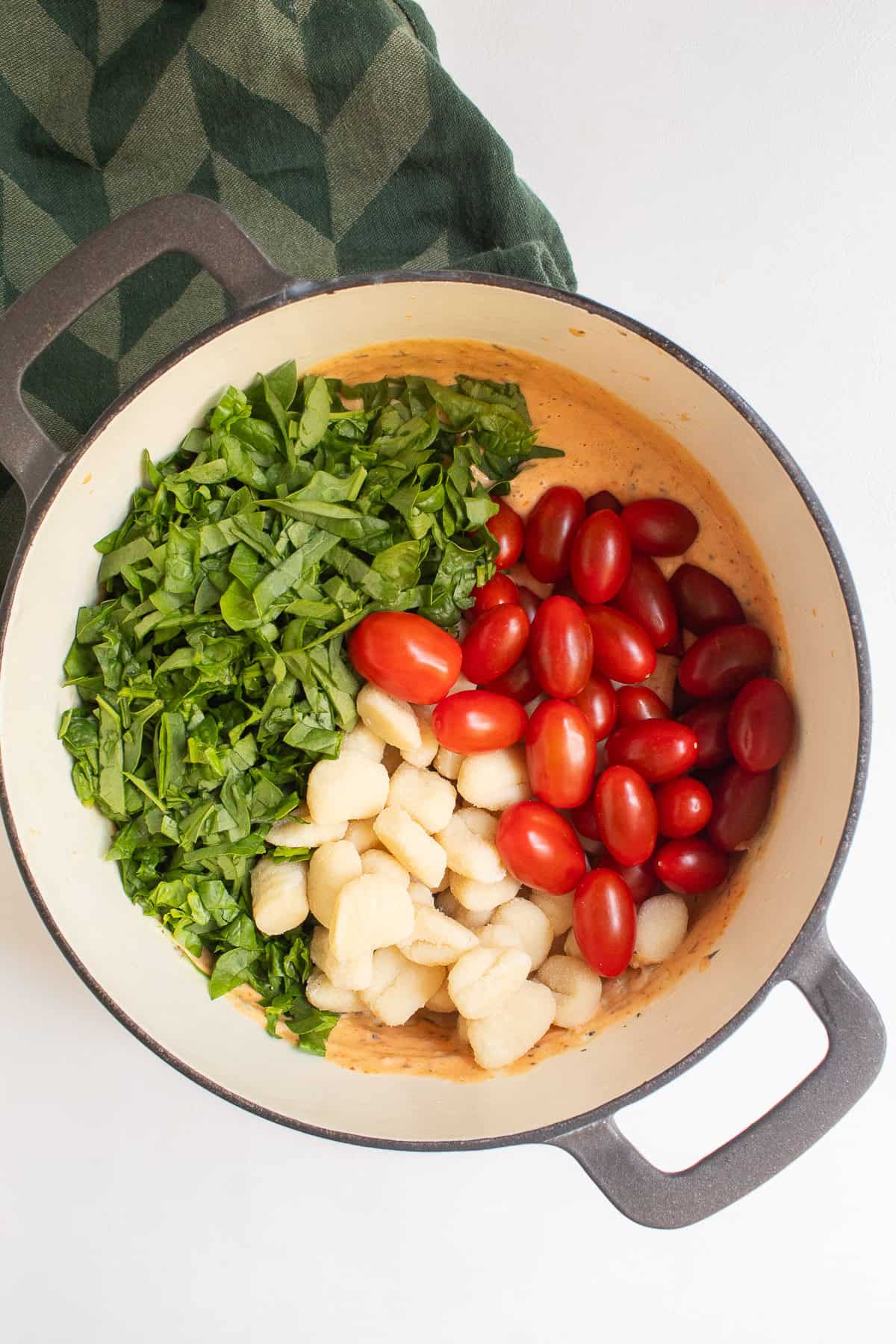 Fresh tomatoes, gnocchi, spinach, and basil are added to the sauce.