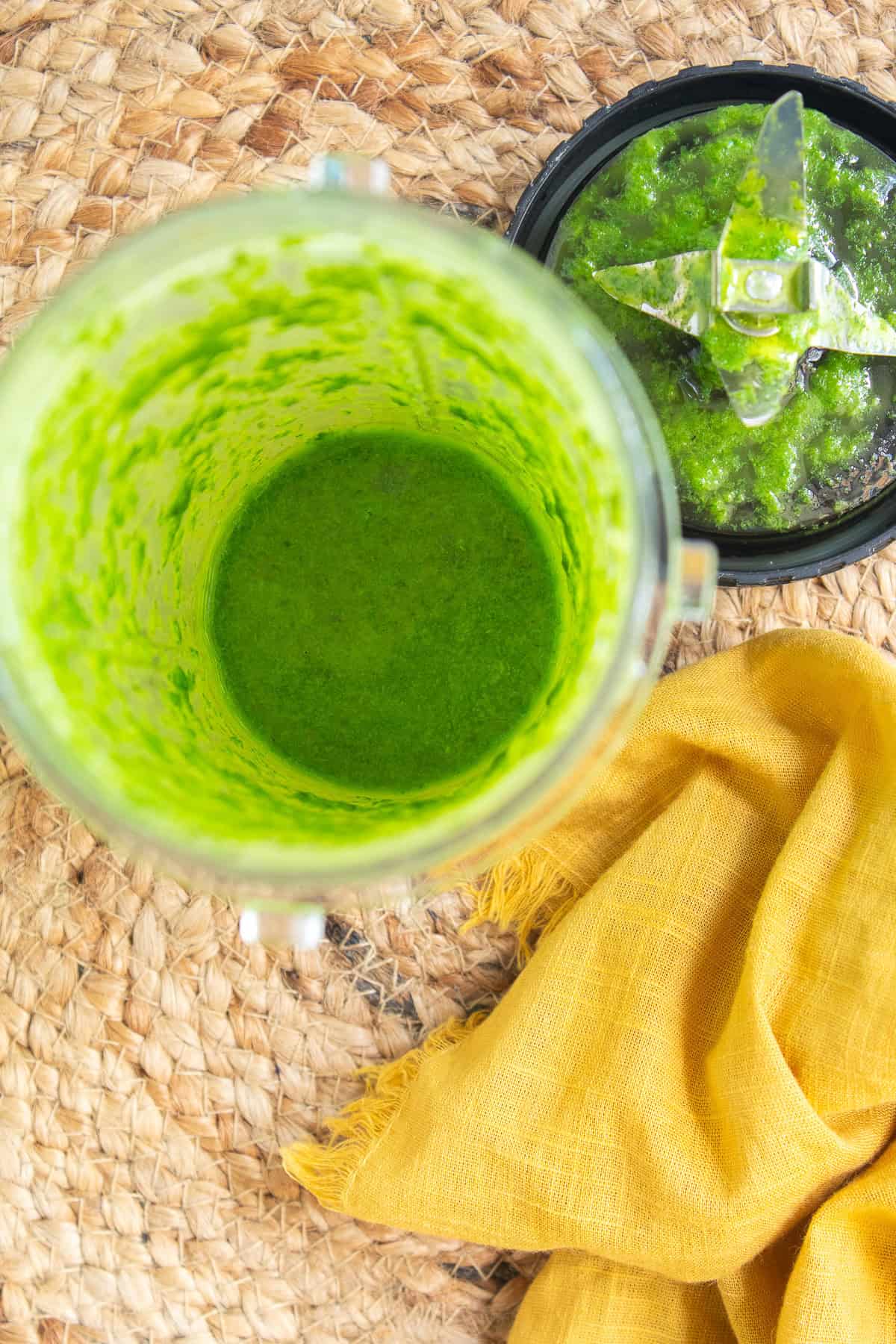 The blended basil and oil is bright green in the bottom of the blender.