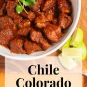 Tender chunks of pork are coated with a brick red sauce in a white bowl. A white text box at the bottom of the image contains the words, "chile colorado" and "plan. eat. post. repeat."