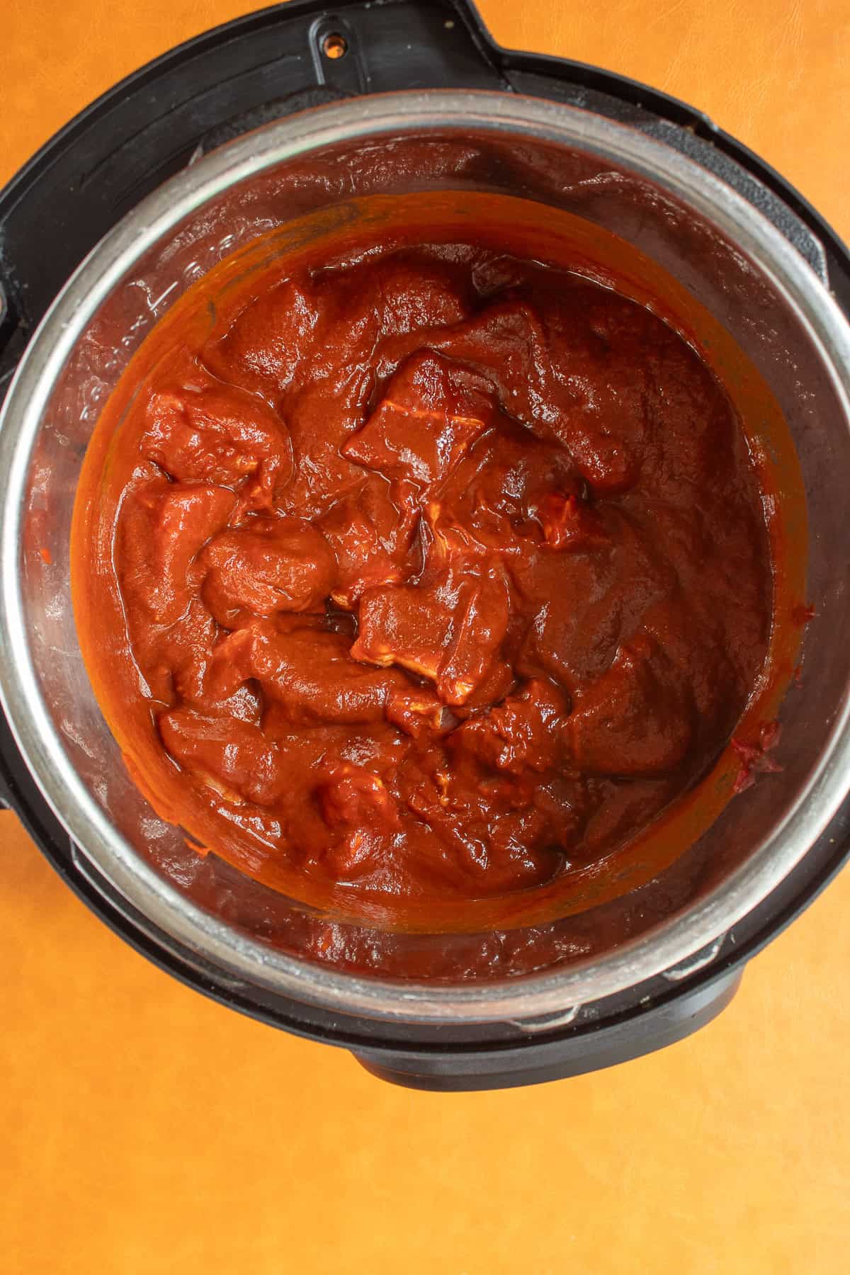 Sauce coats chunks of pork shoulder before cooking in the Instant Pot.