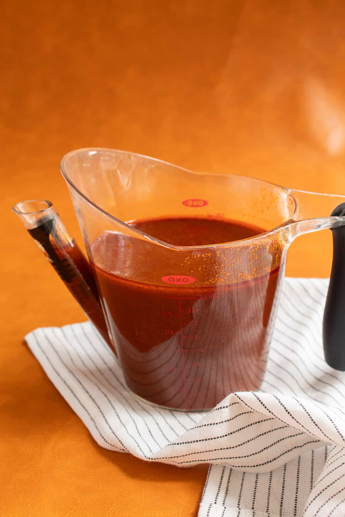 The sauce is transferred to a gravy separator to remove the oily layer.