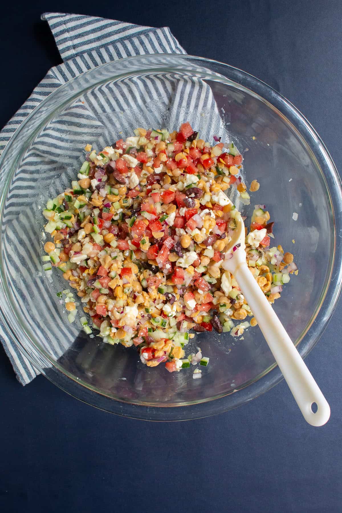 The dip is mixed in a large glass bowl until the ingredients are evenly distributed.