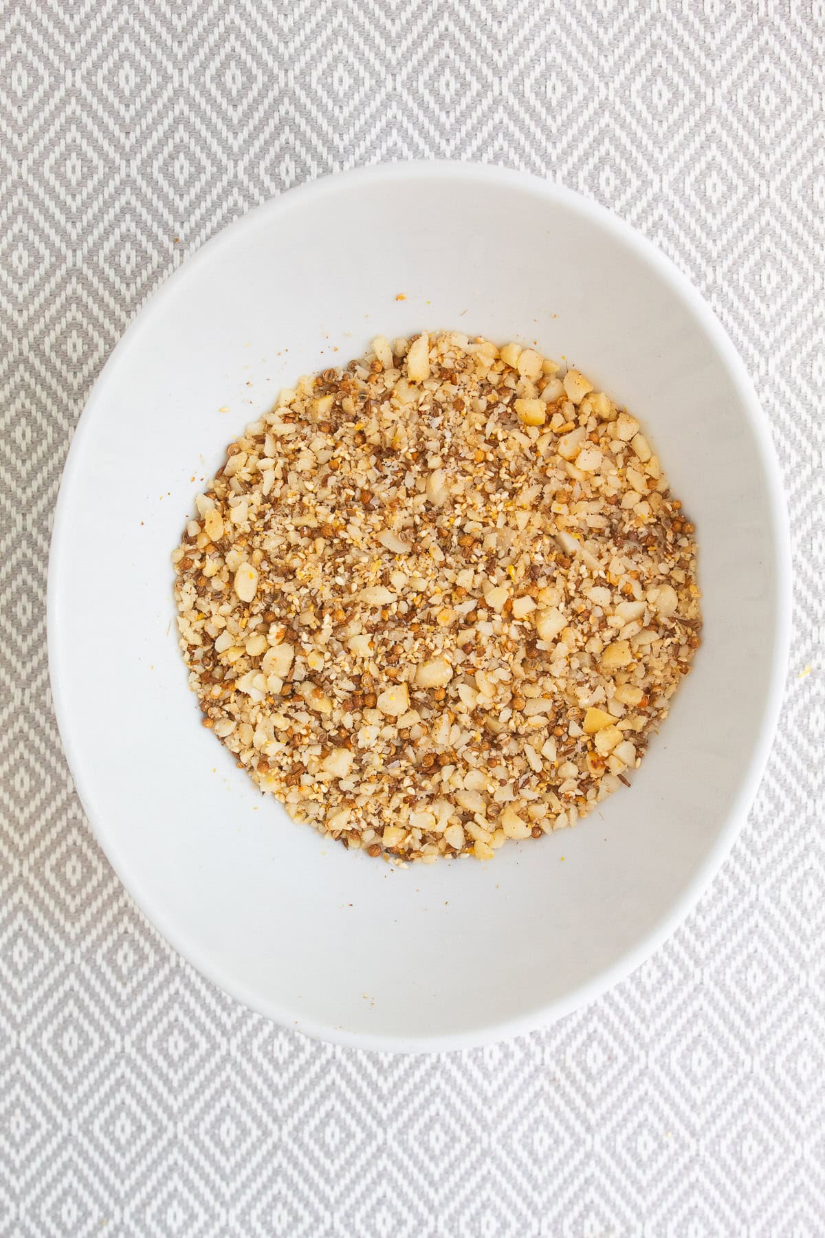 The mixed dukkah is a golden color with whole and crushed seeds and macadamia nuts visible.