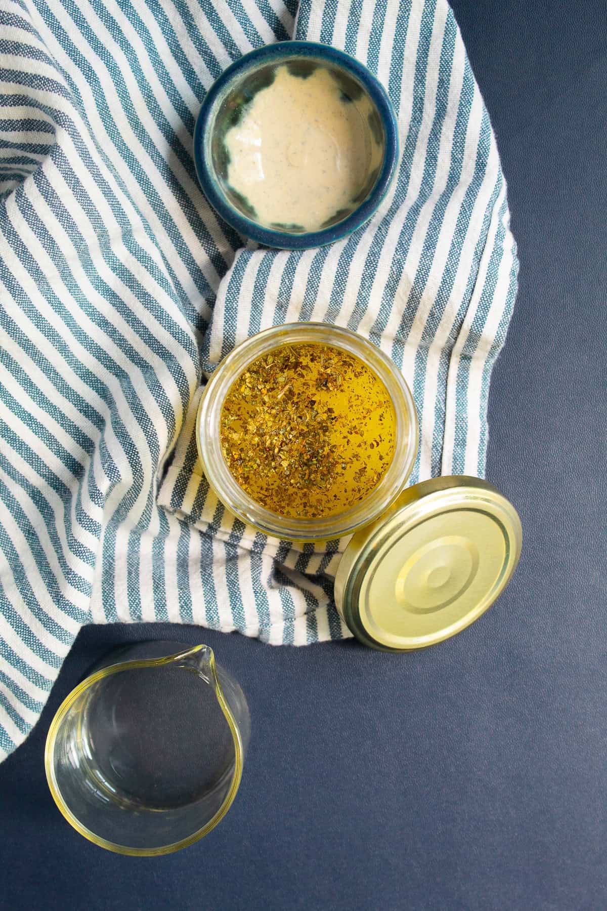 The Greek salad dressing ingredients are added to a jar with a tight fitting lid.