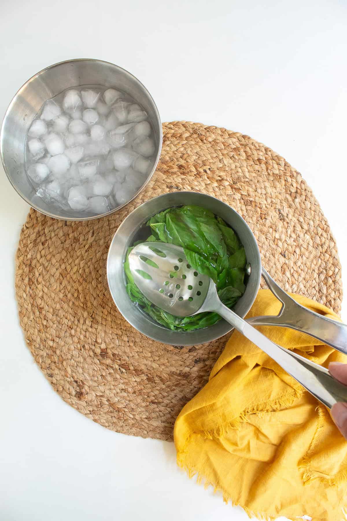 Basil leaves are placed into boiling water to quickly cook them.
