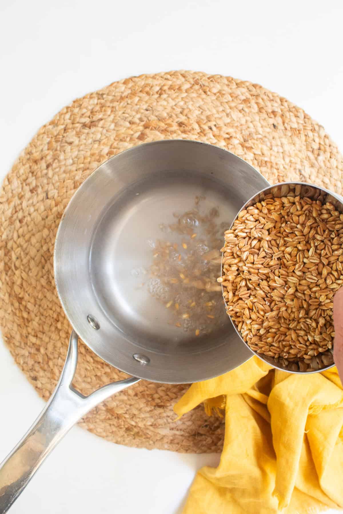 Farro is added to boiling water in a saucepan.