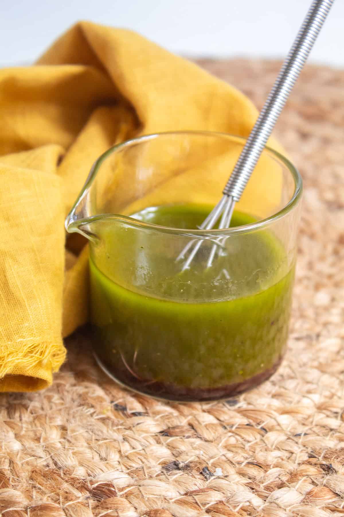 Red vine vinegar, salt, and pepper are added to the basil oil to make a vinaigrette.