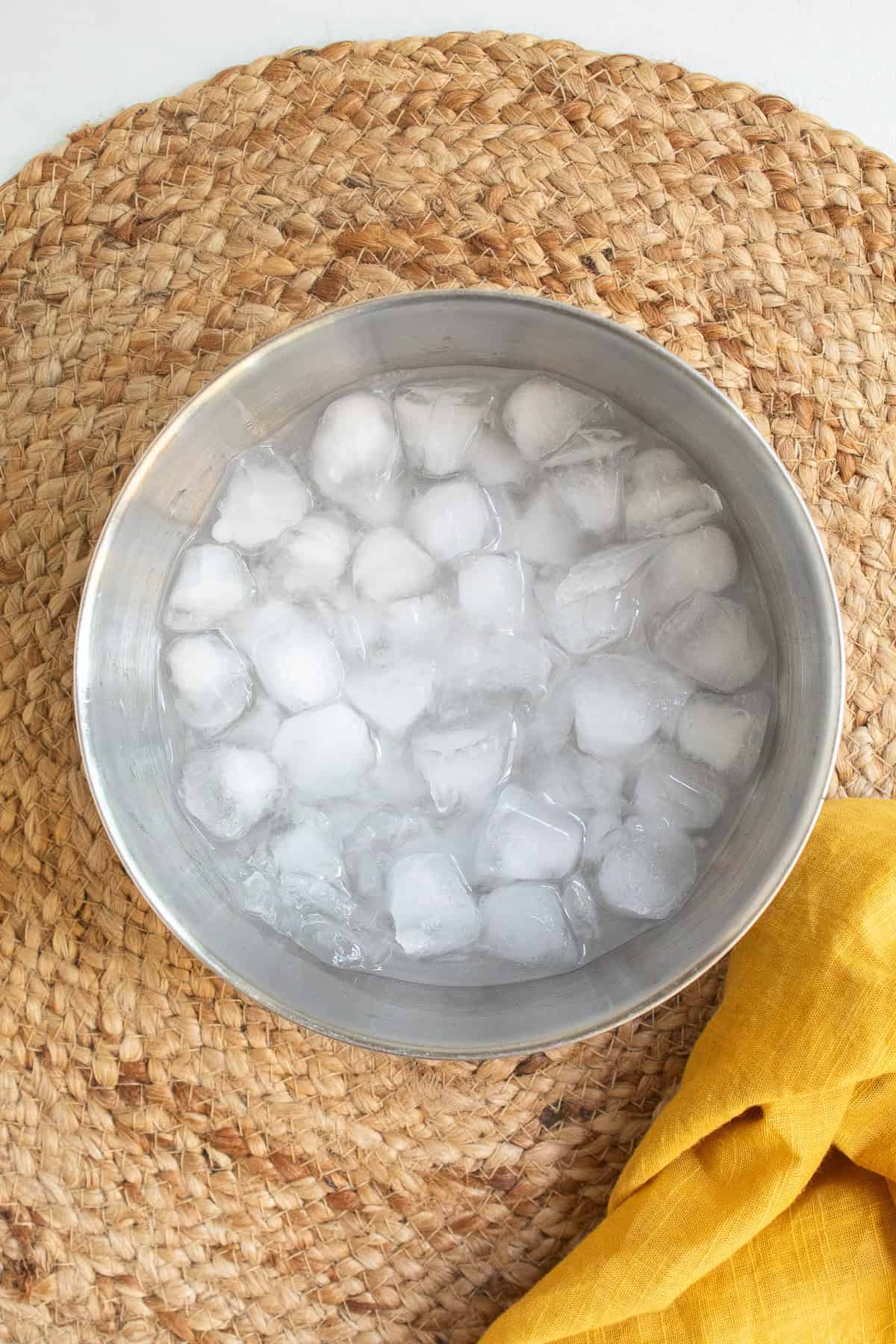 An ice bath in a stainless steel bowl.