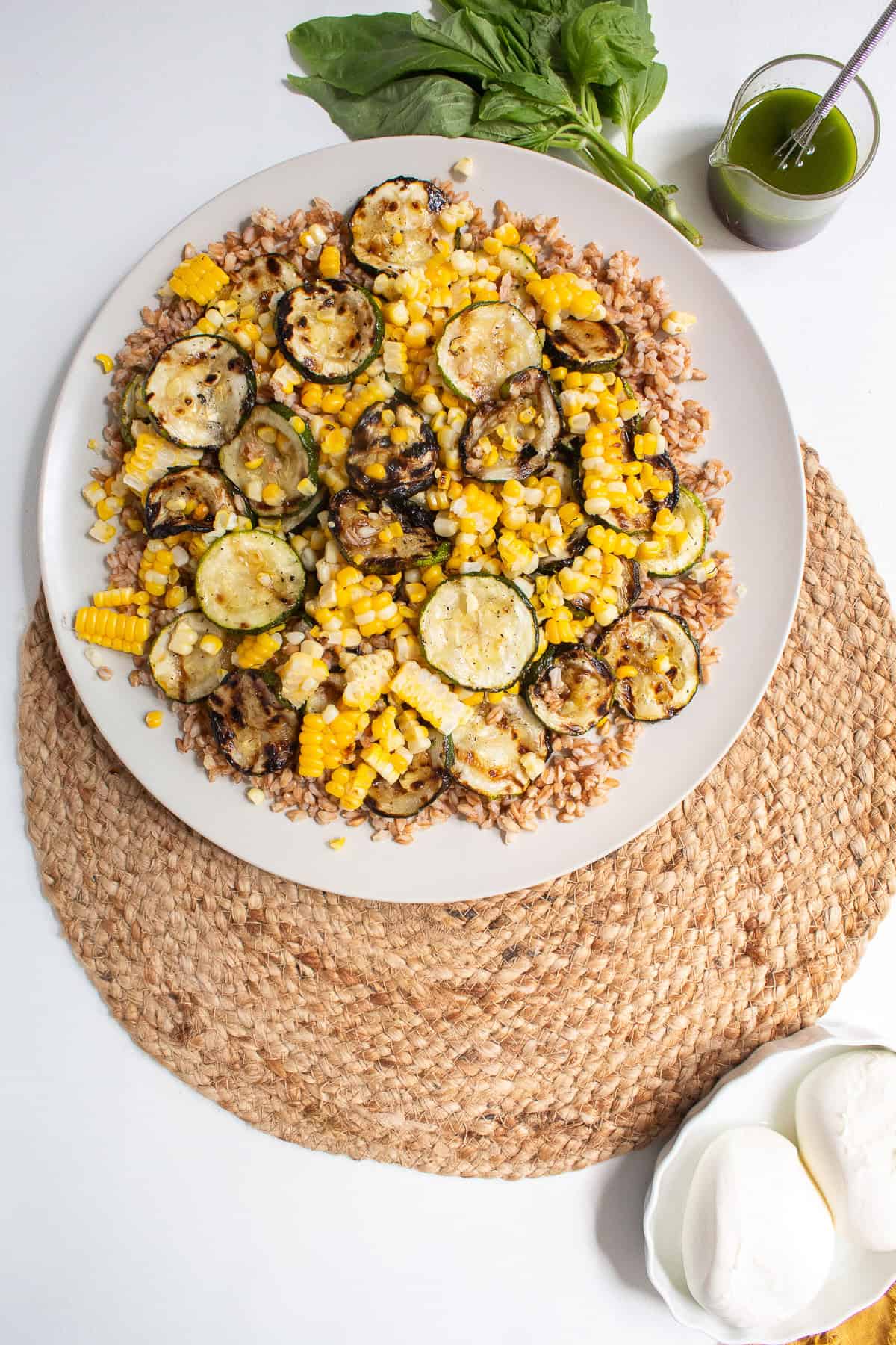 Grilled corn and zucchini piece are added to the farro layer.