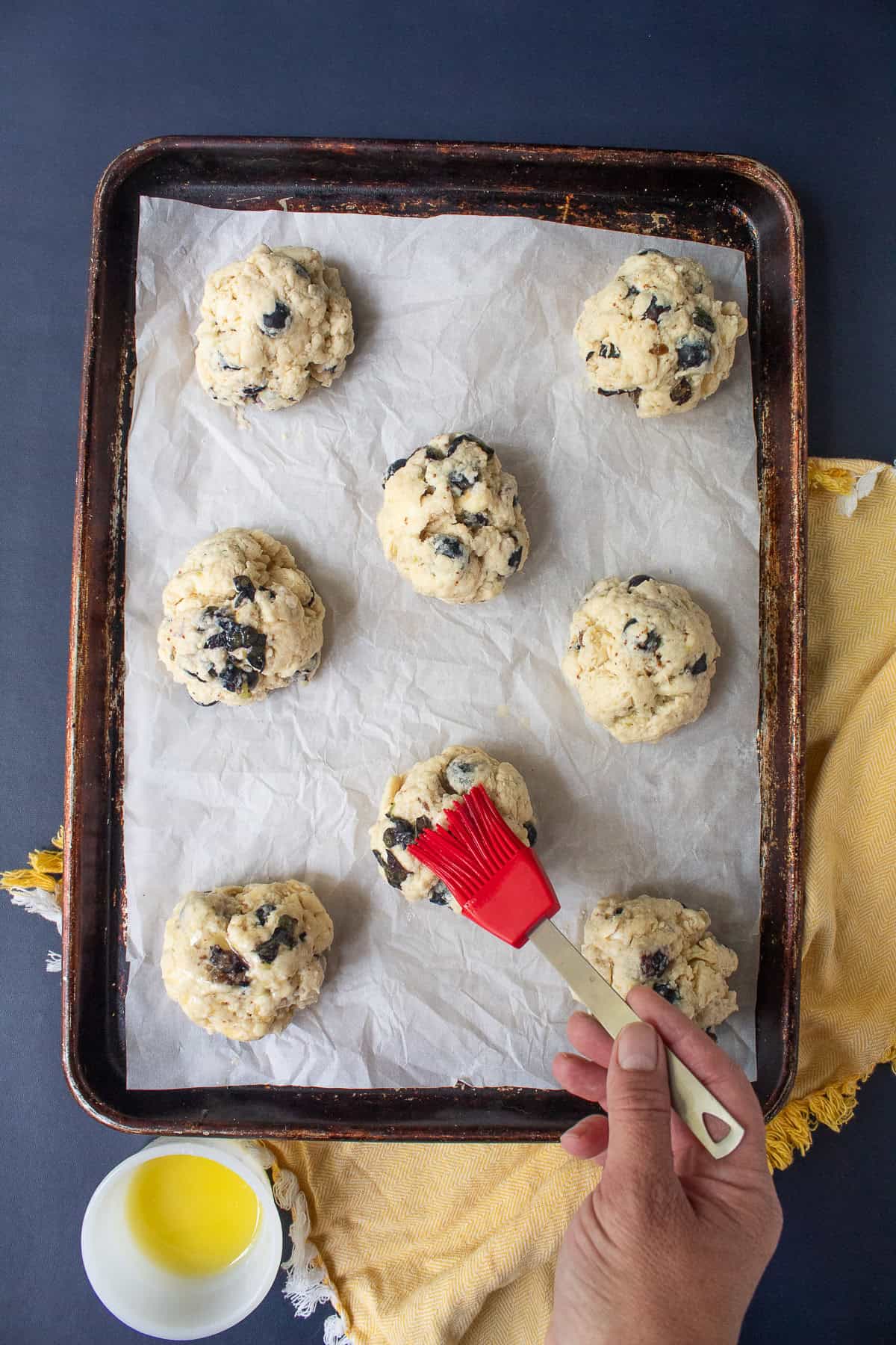 The biscuit dough is brushed with melted butter.