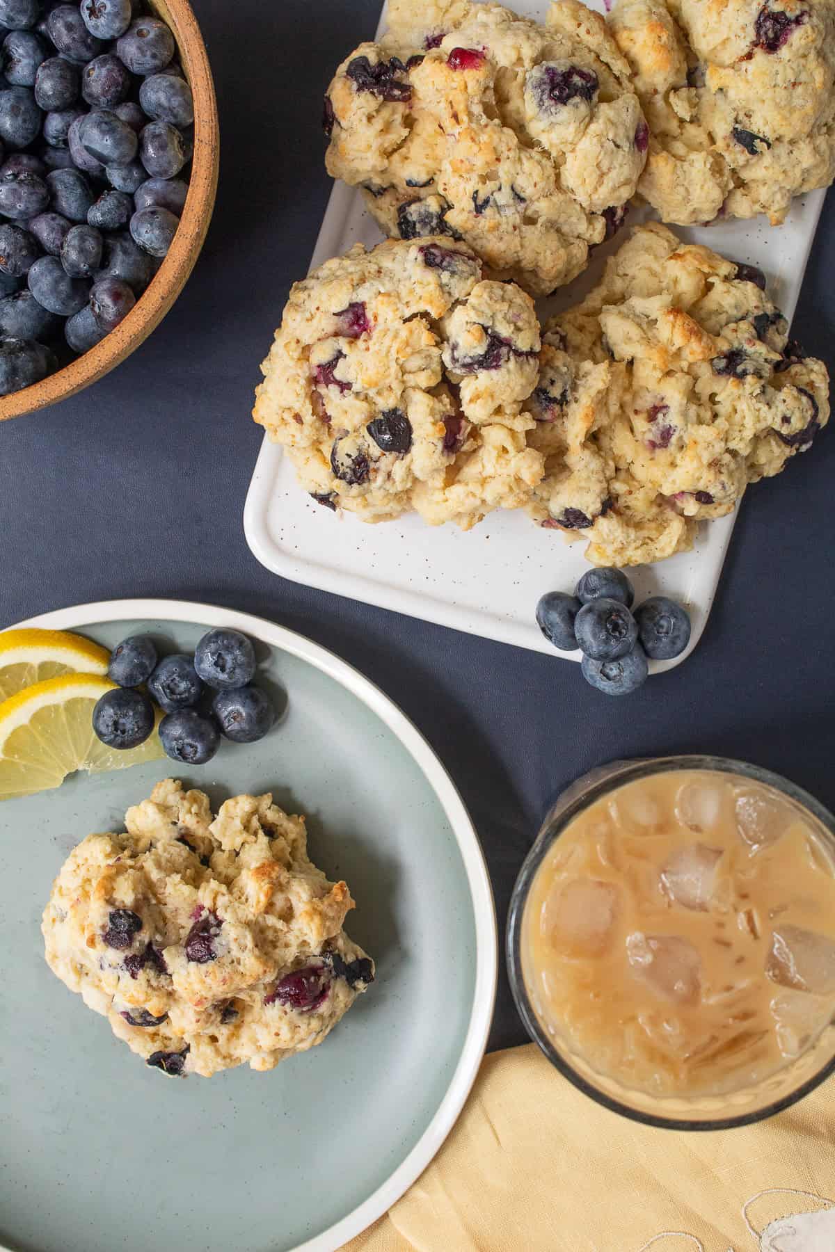A blueberry biscuit is served alongside iced coffee.