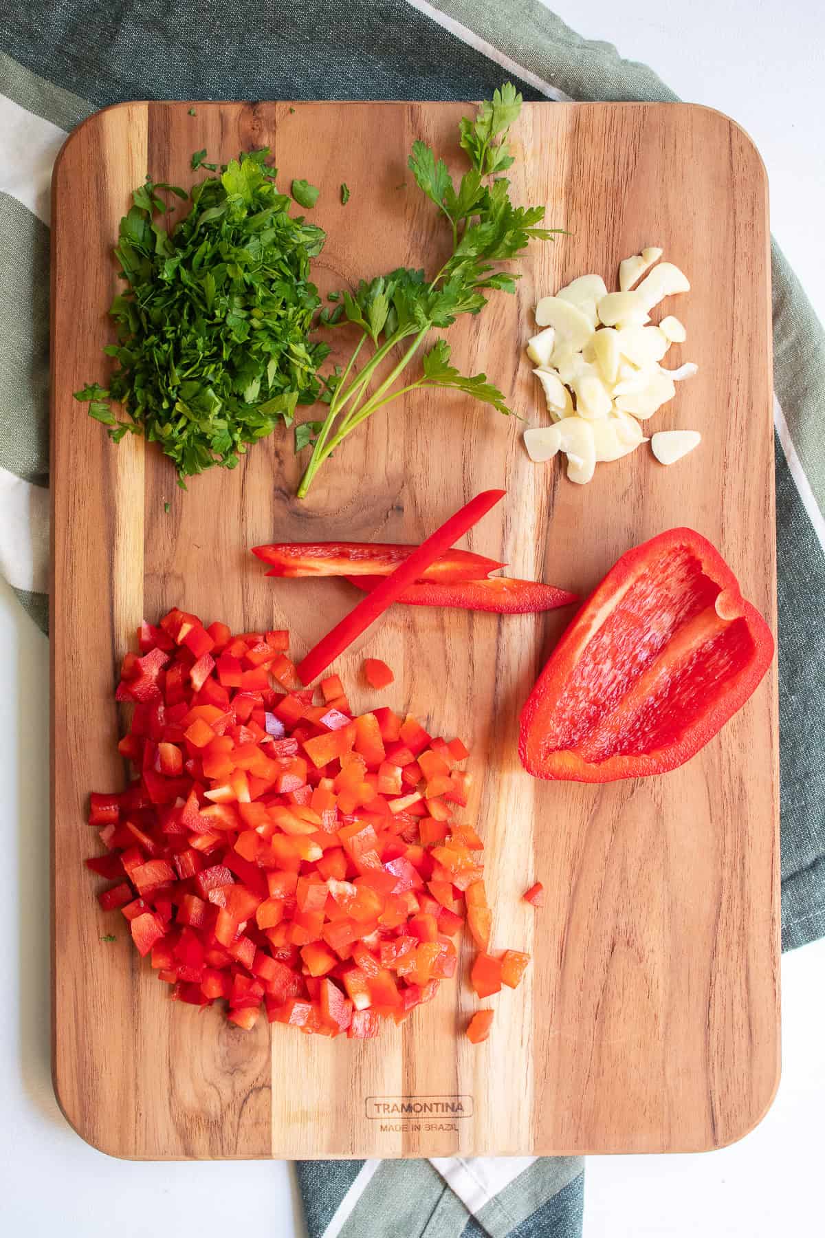 Ingredients are chopped on a wooden cutting board in preparation of the meal.