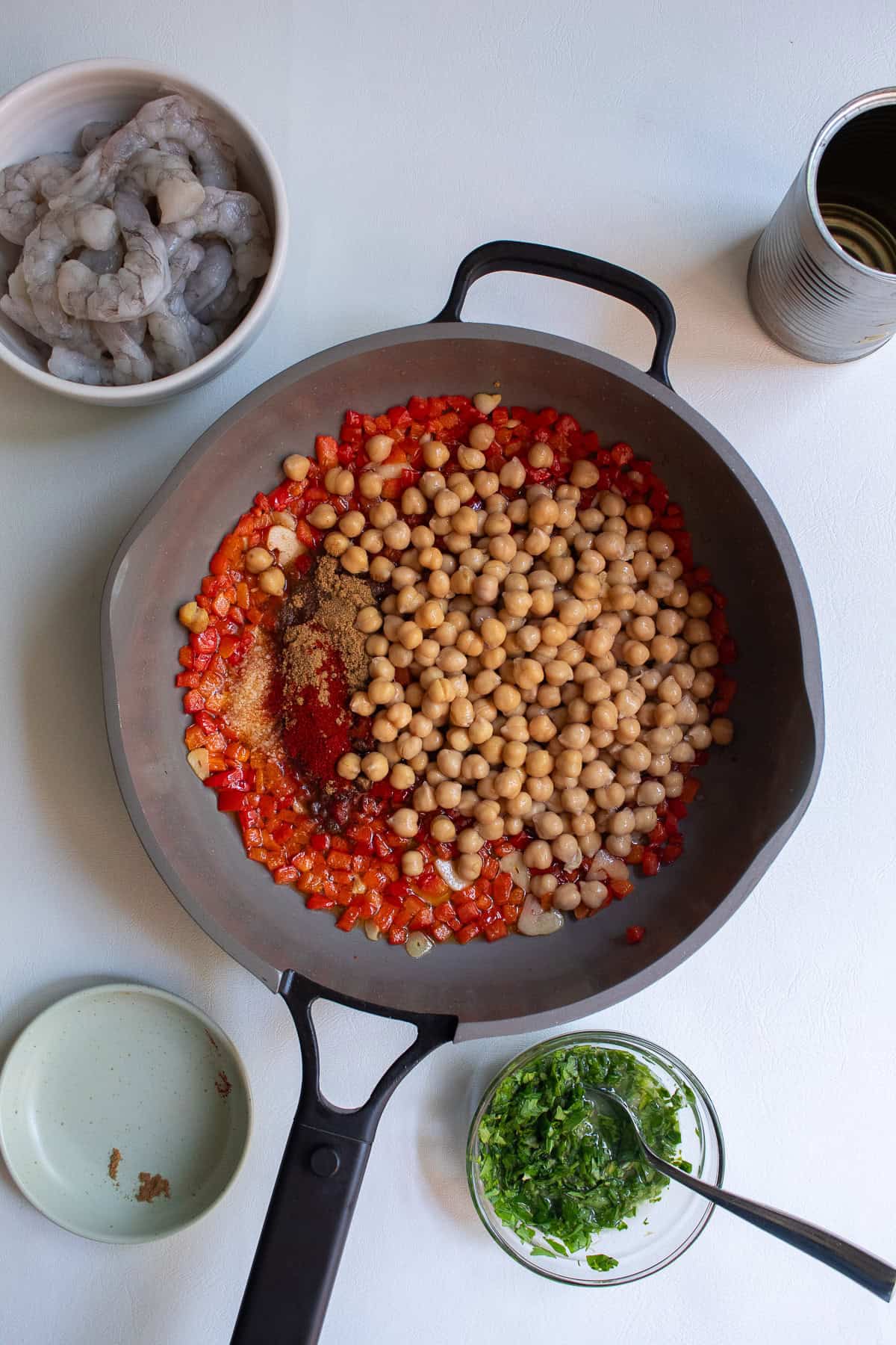 Spiced and chickpeas are added to the cooked peppers and garlic.