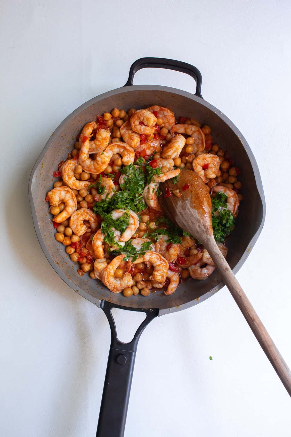 The lemon and parsley mixture is added to the skillet with the cooked shrimp and chickpeas.