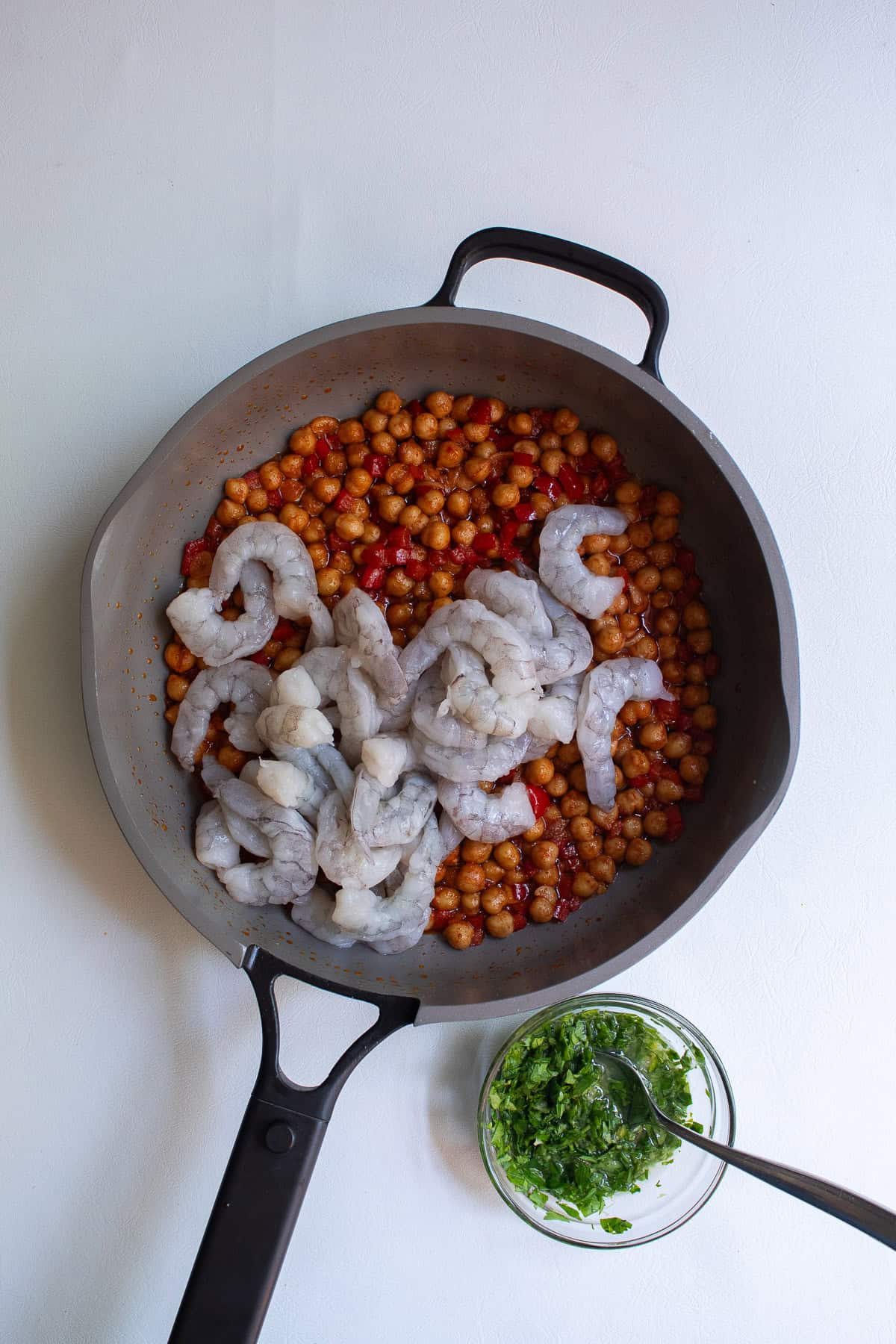Shrimp are added to the chickpea and pepper mixture.