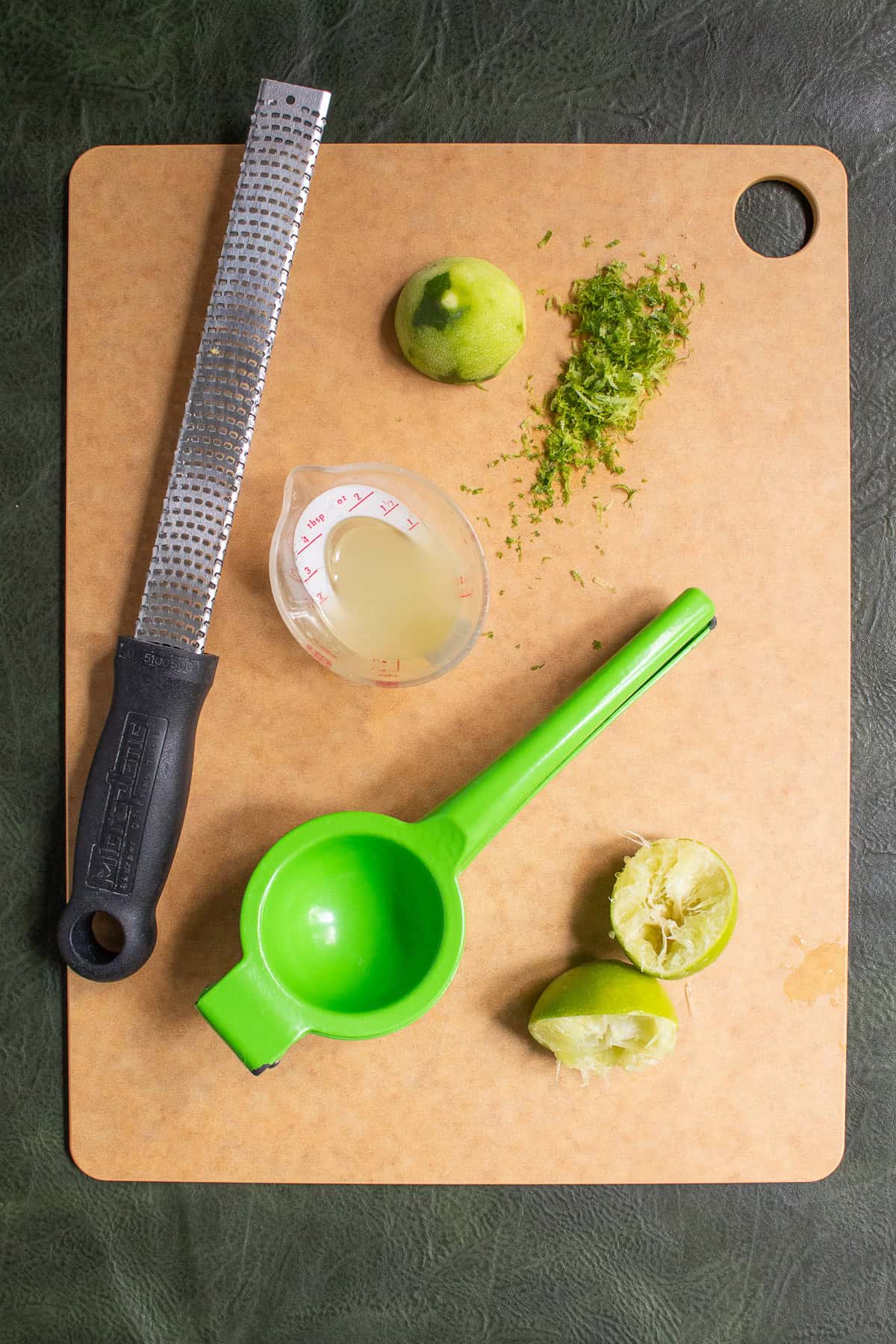 Limes are zested with a microplane and then juiced with a green citrus squeezer.