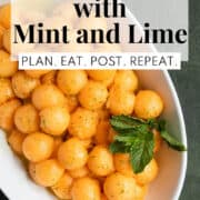 An oblong white bowl is piled with cantaloupe melon balls speckled with mint and line zest and garnished with mint leaves. A white text box at the top of the image contains the words, "melon salad with mint and lime" and "plan. eat. post. repeat."